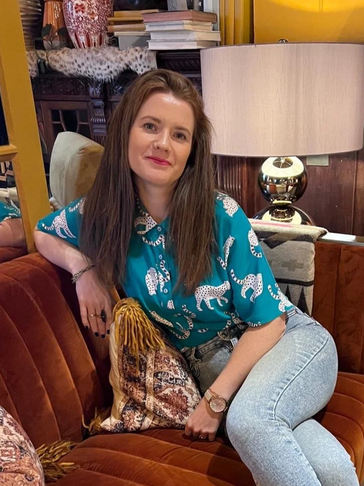 Alison Boote, graphic designer, seated in a colourful interior
