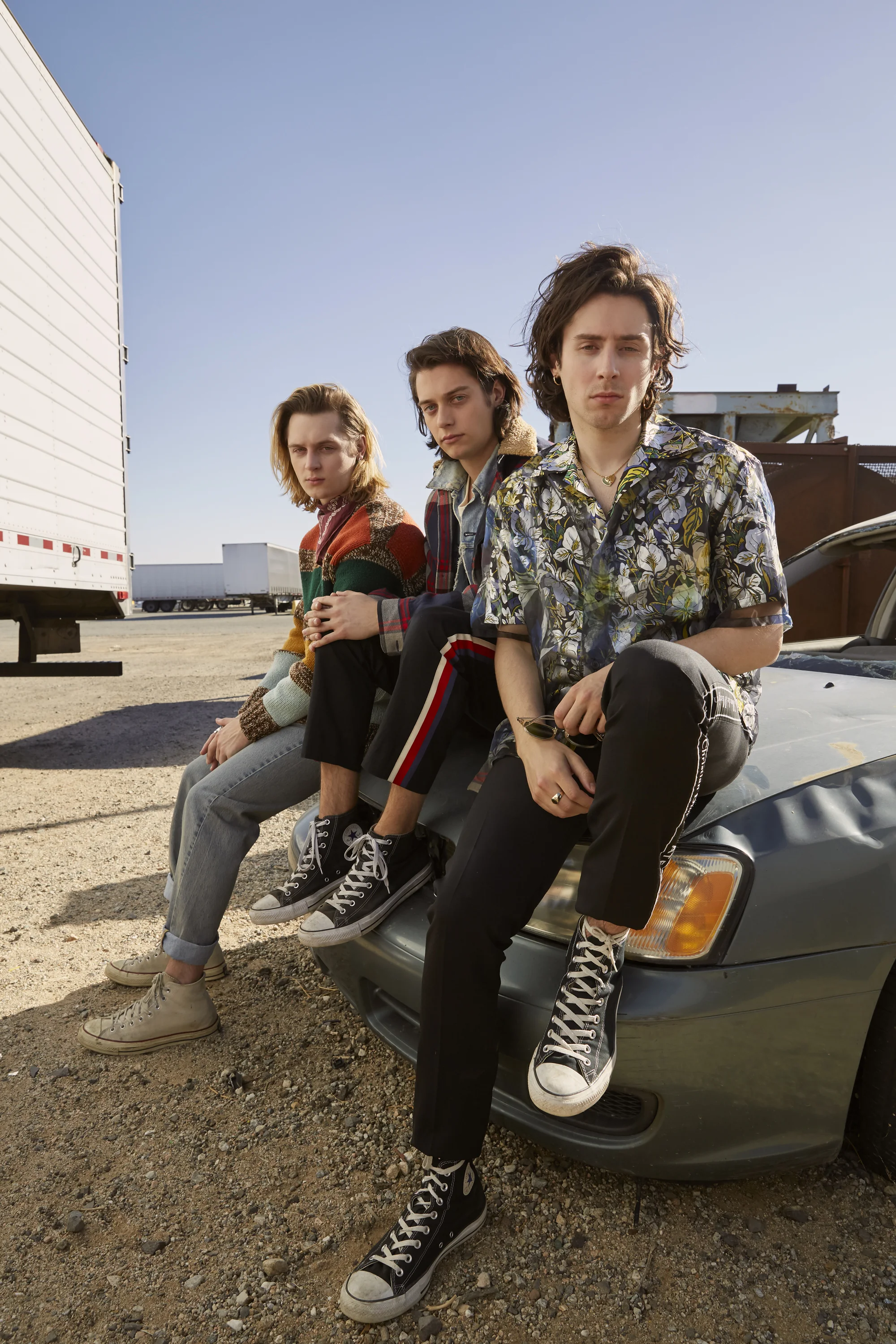Left to right: GUCCI sweater and jeans, LEVI’S bandana, and CONVERSE shoes. NEW NOSTALGIA jacket, GUCCI shirt, t-shirt, and pants, and CONVERSE shoes. LOUIS VUITTON shirt, DIOR HOMME pants, and CONVERSE shoes.