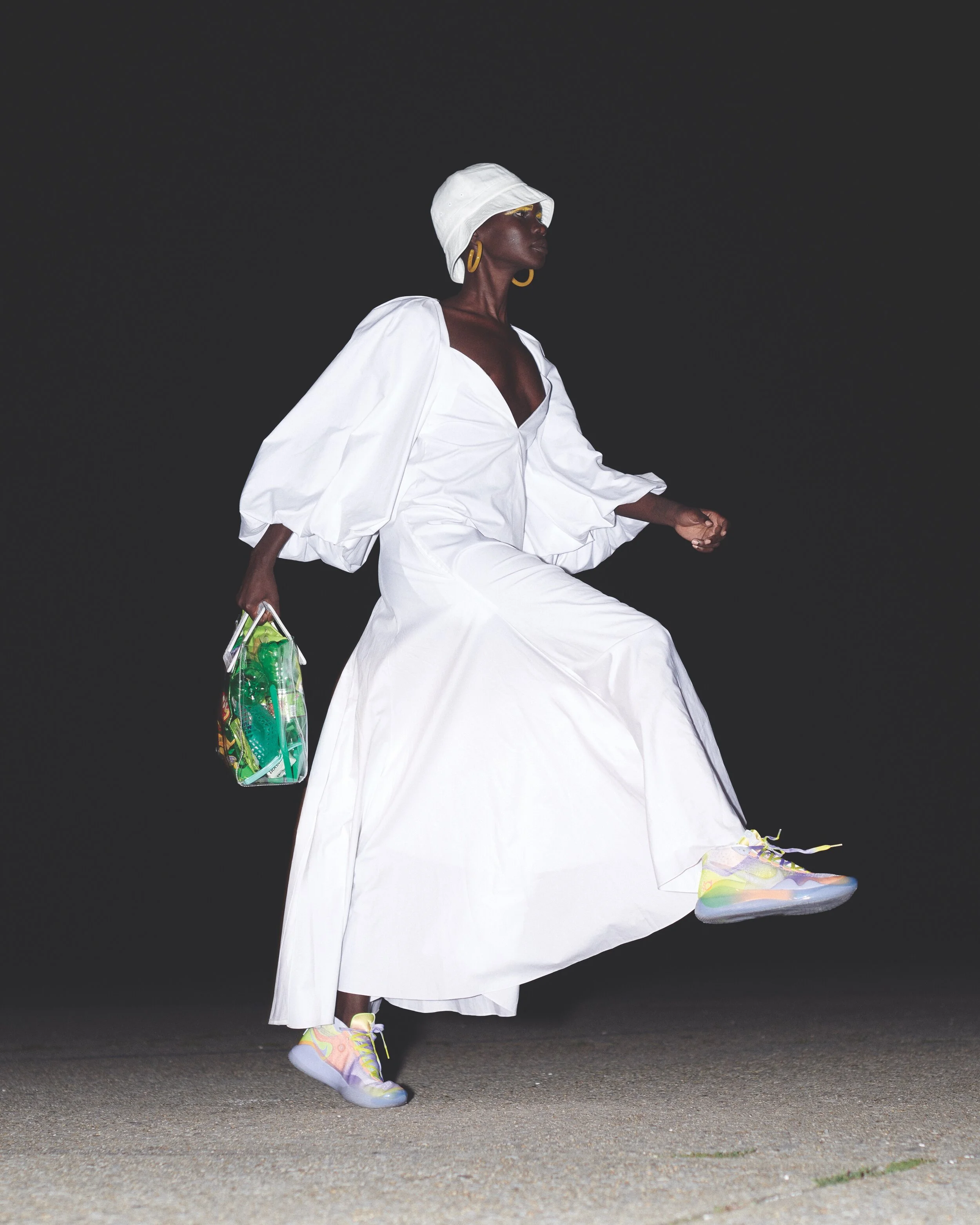 KHAITE dress, NIKE shoes, HAVE A GOOD TIME hat, MACHETE earrings, and stylist’s own bag.