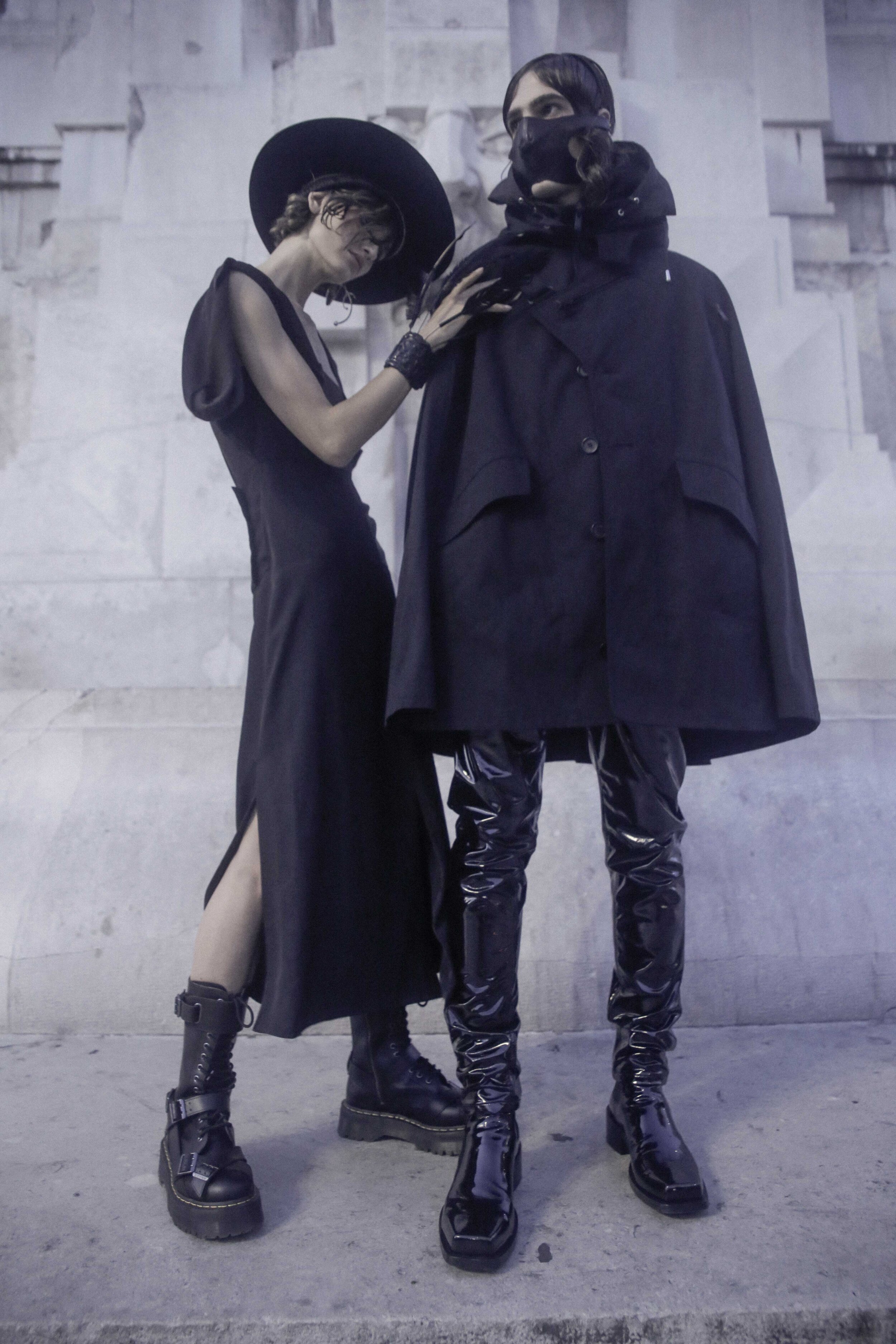 Left to right: BOTTEGA VENETA dress, GIVENCHY hat, FLAVIA CAVALCANTI feather piece, and DR. MARTENS shoes. LES HOMMES cape and coat, TOM REBEL pants and mask, and GIVENCHY boots.