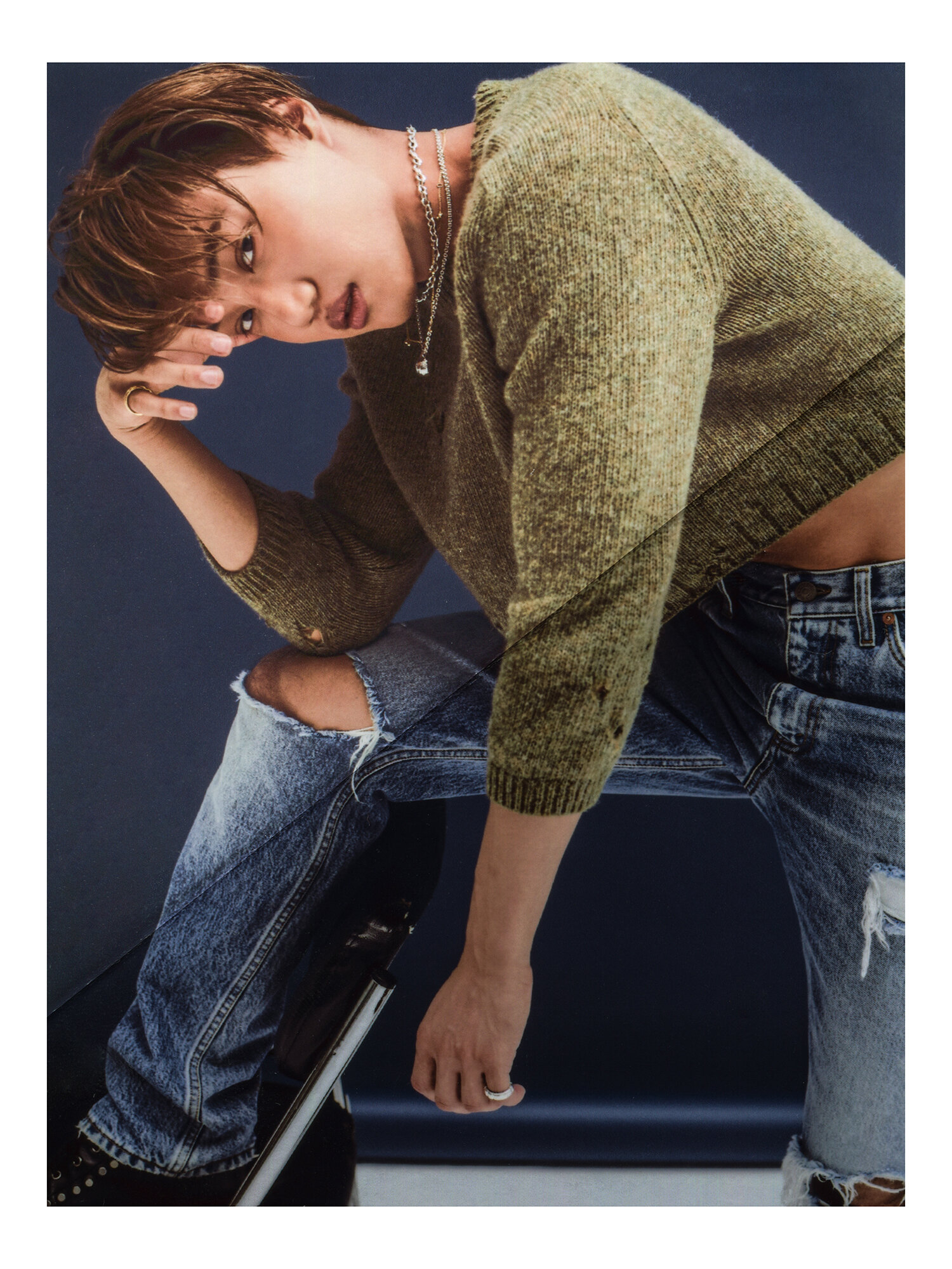 Kai wears GUCCI sweater, jeans and shoes. ISABELLA ETOU necklaces.