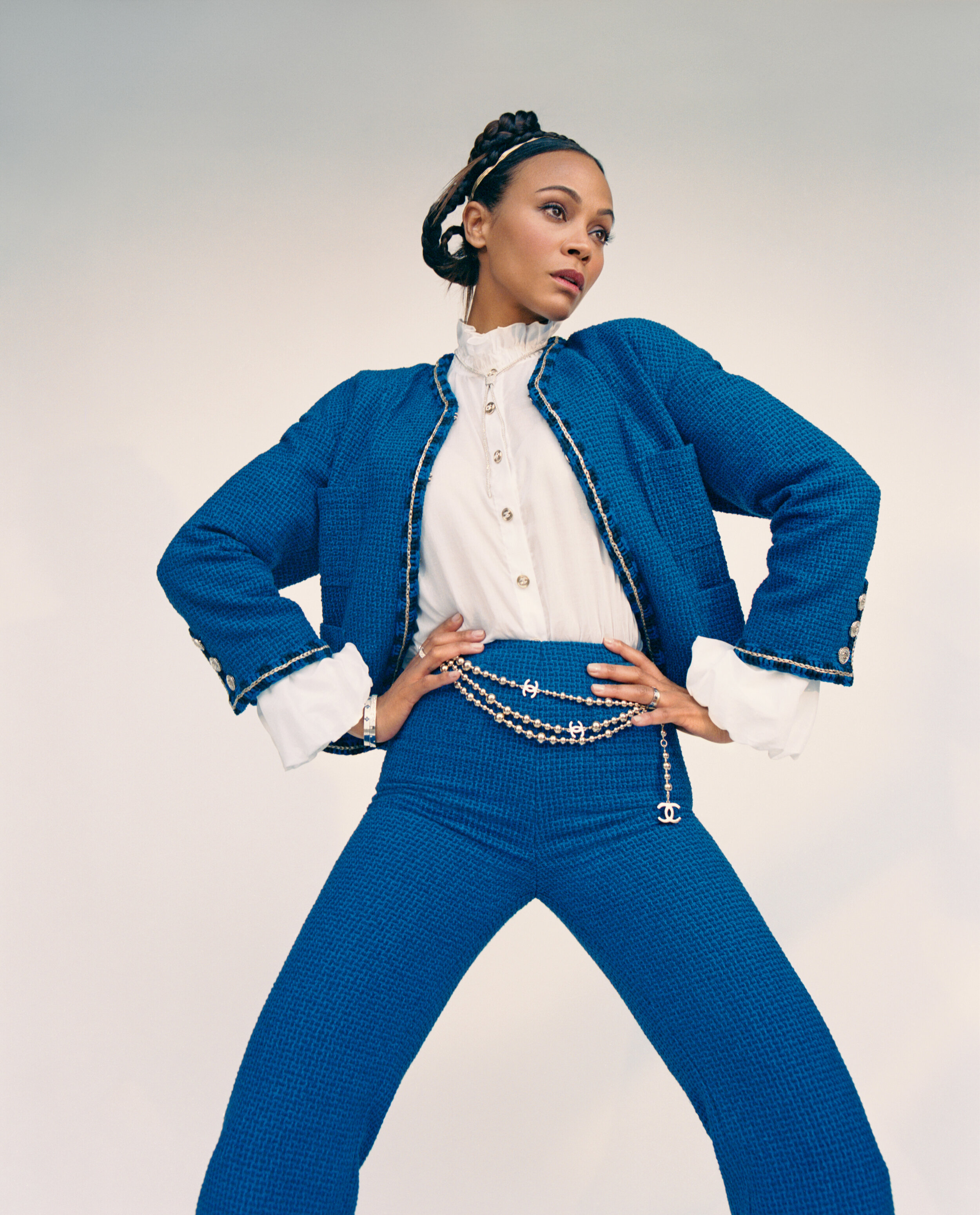 CHANEL jacket, top, pants, and belt and ROBERTO COIN earring, necklace, bracelets, and rings.