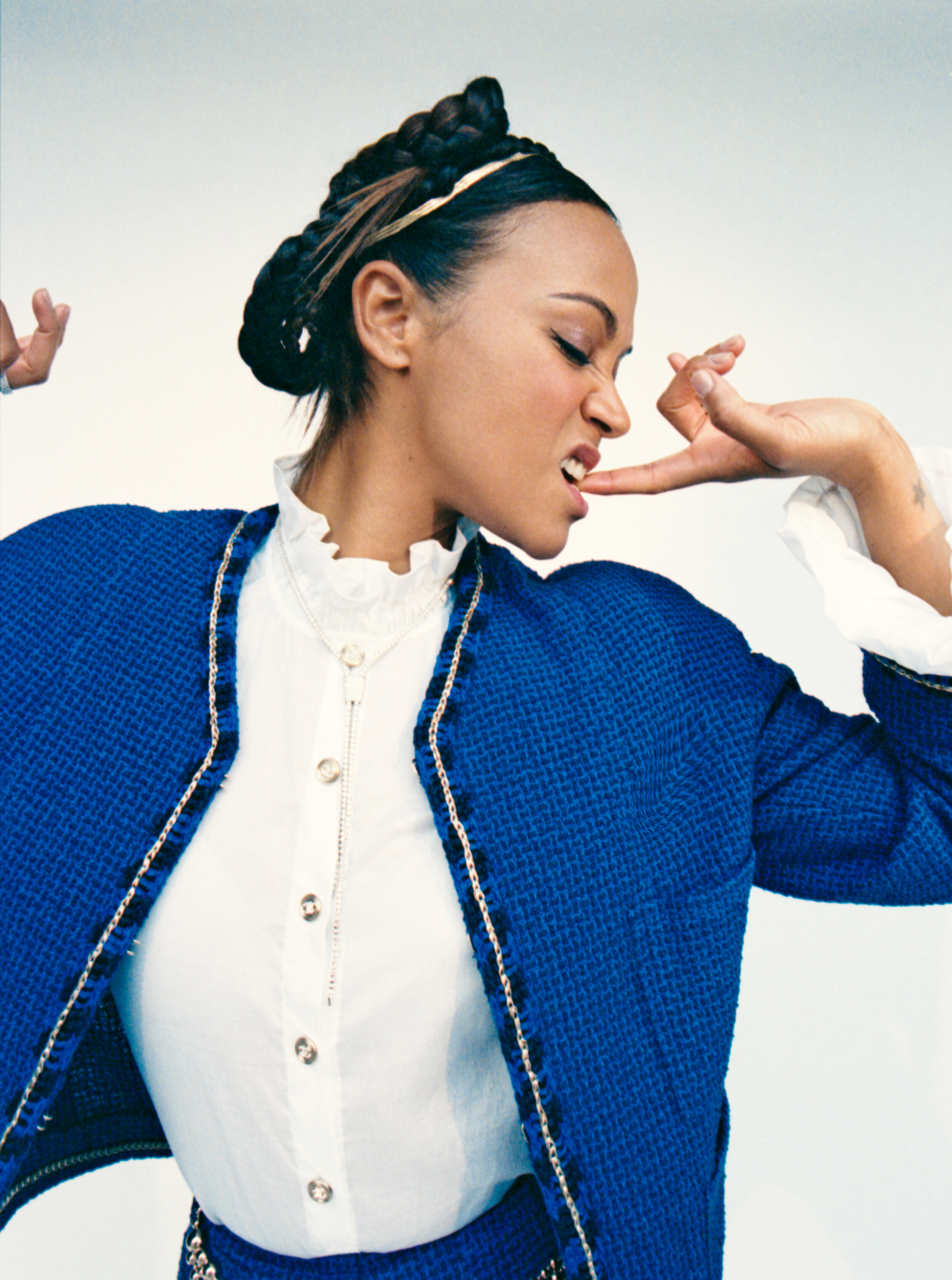 CHANEL jacket, top, and belt and ROBERTO COIN earring, necklace, bracelets, and rings.