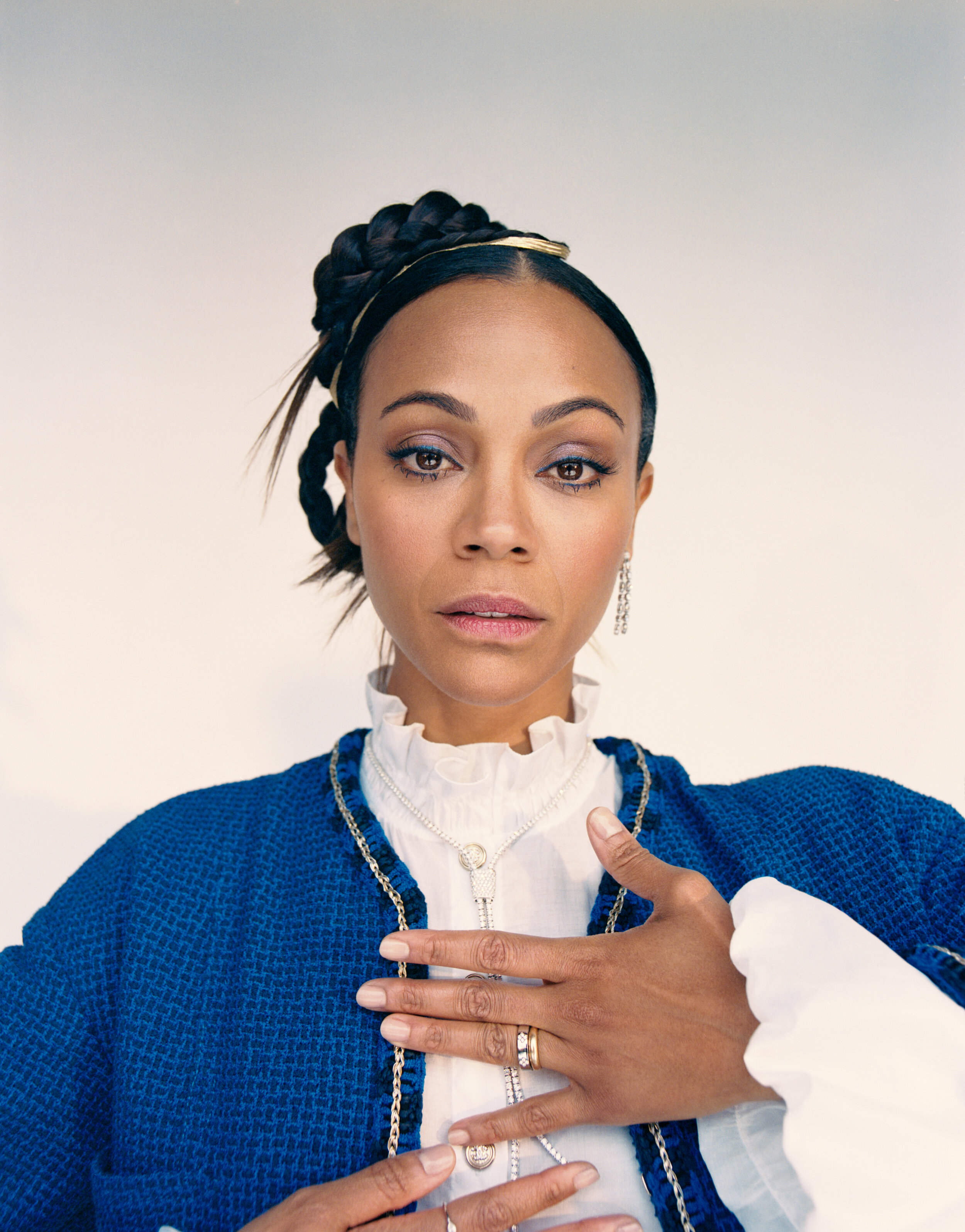 CHANEL jacket, top, and belt and ROBERTO COIN earring, necklace, bracelets, and rings.