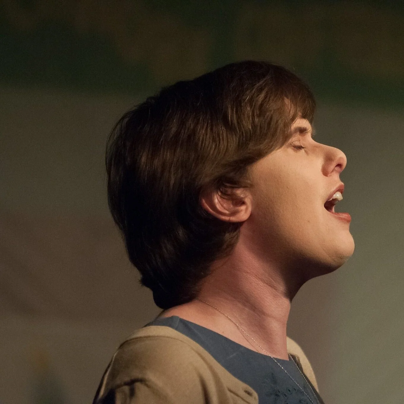 Image Description: Emily Rose Cole with short hair, eyes closed, singing.