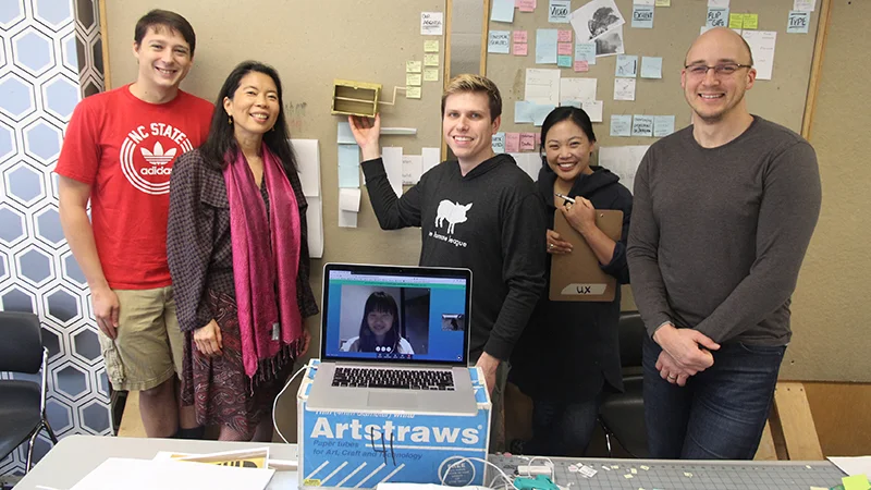 The team, all smiles posing with prototypes in the studio.