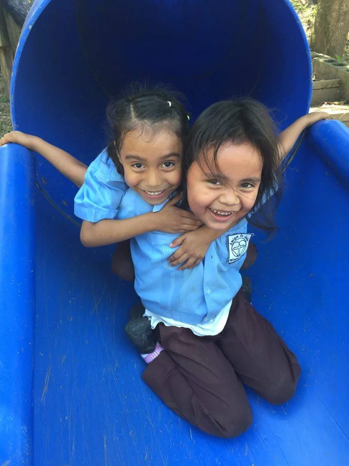 Josefina and friend play on the slide