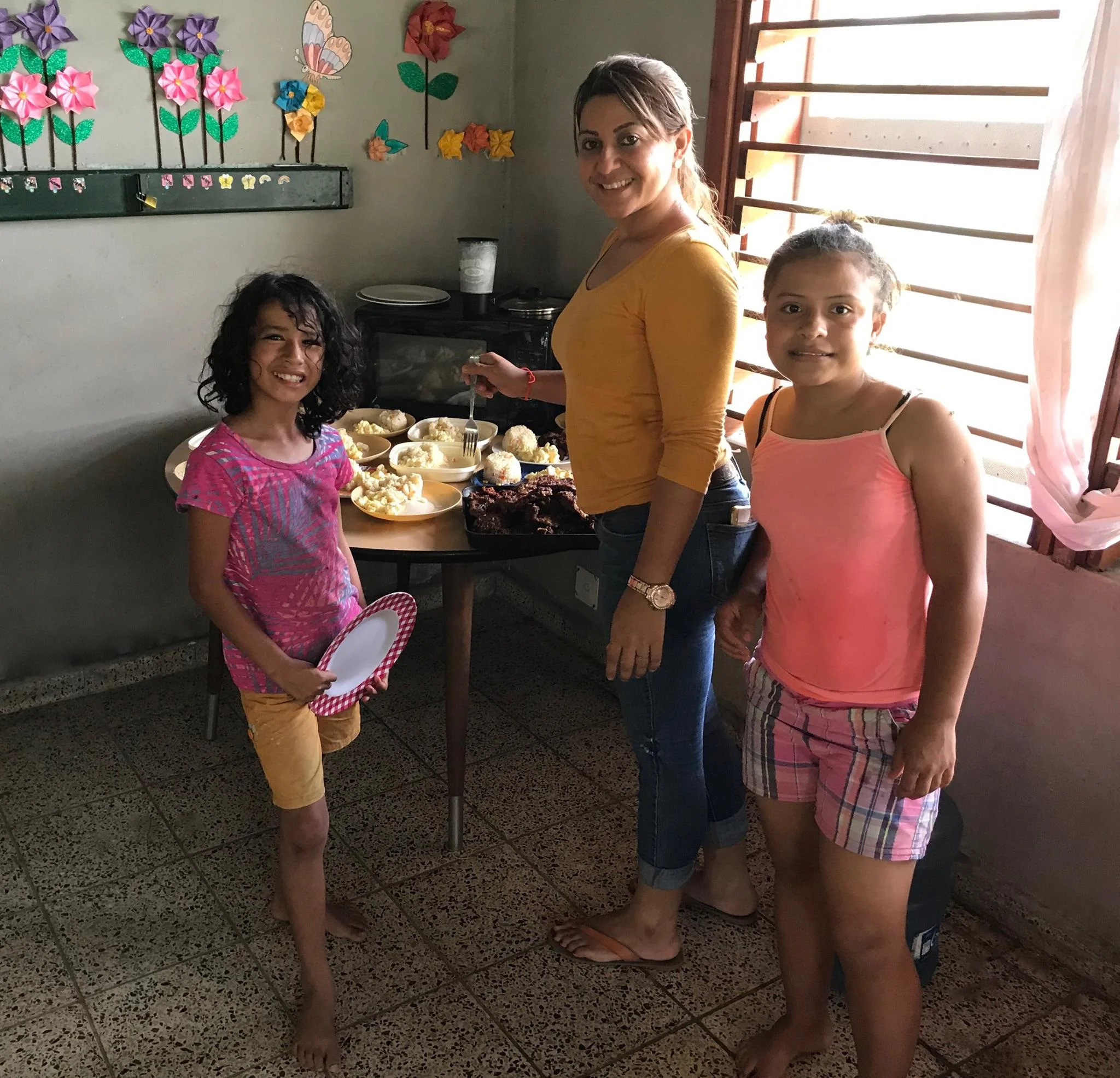 Felipa* (left) helping her 'madrina' prepare lunch in her dorm, Hogar 2.