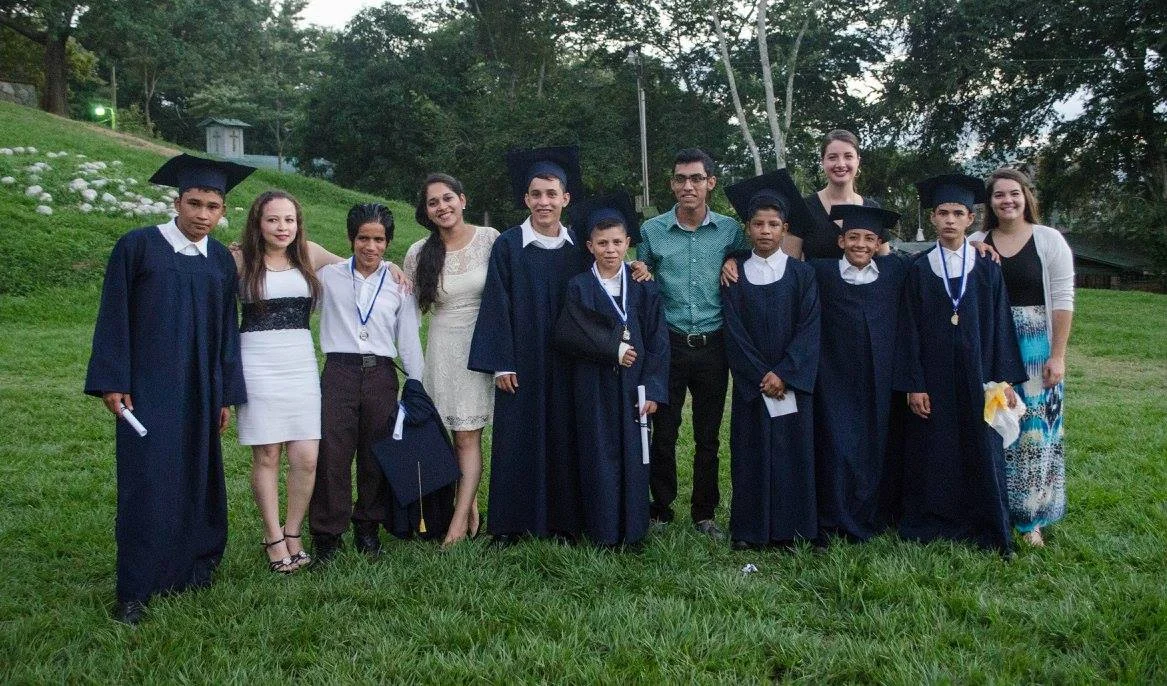 Profe Evelyn (fourth from the left) at the 2016 Graduation Ceremony along with the boys who graduated from 6th grade that year and their other teachers.