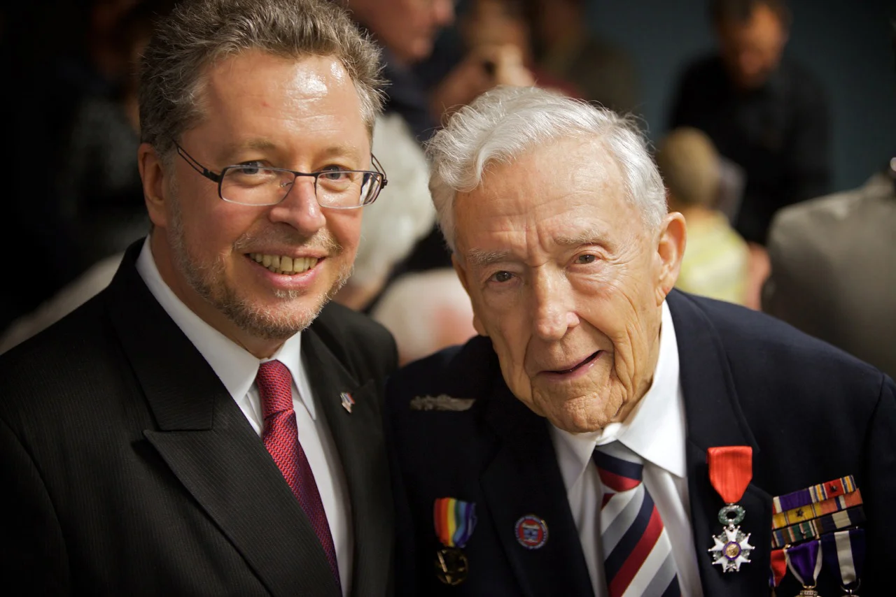 Book Figure 123. Lt. Commander Sherertz with French Legion of Honor medal (left lapel) standing next to French Consulate General Pascal le Deunff. R. Sherertz collection.