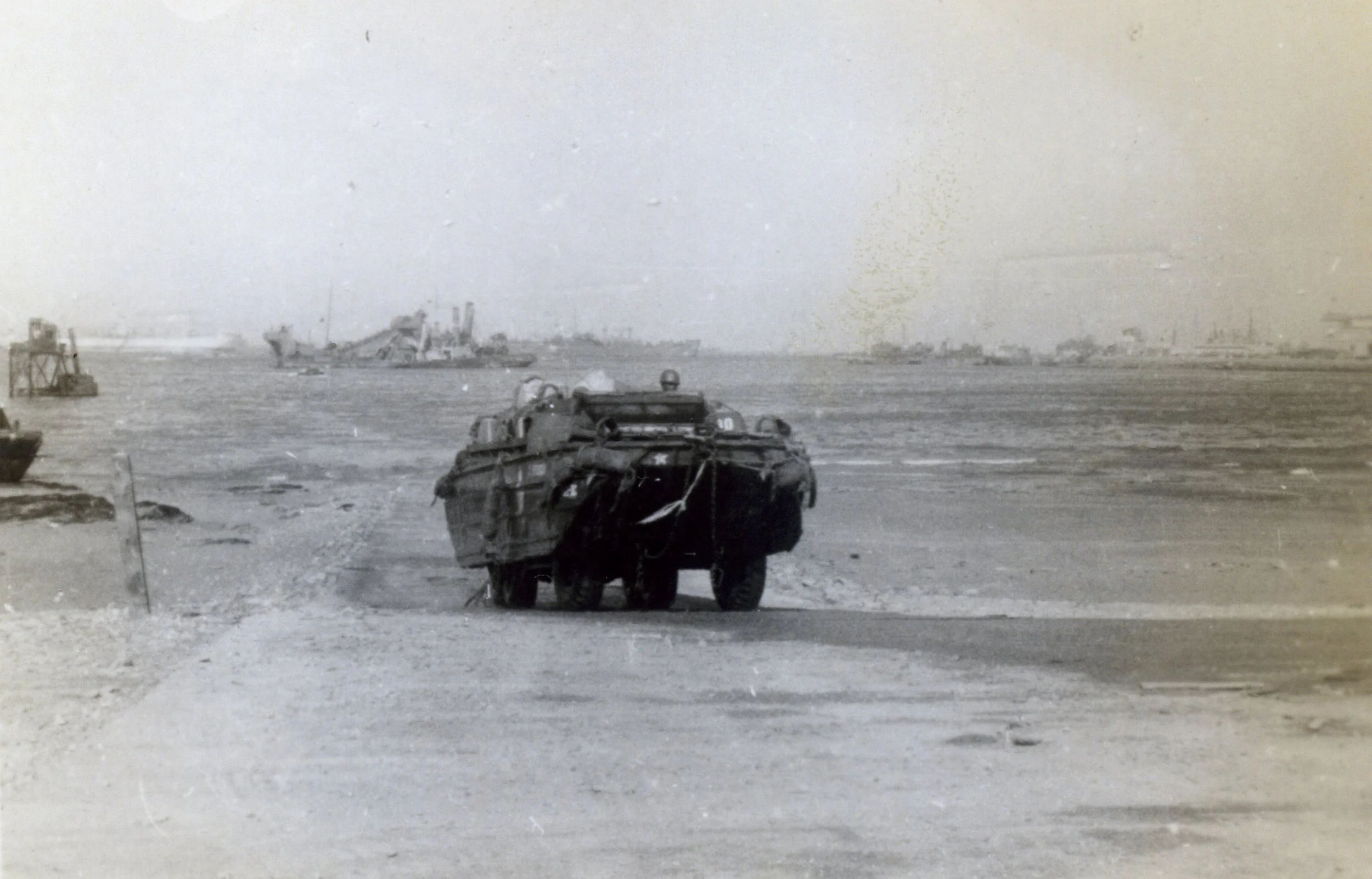 Book Figure 97. Amphibious vehicle coming aground in Cherbourg. Minesweepers clearing mines in the background