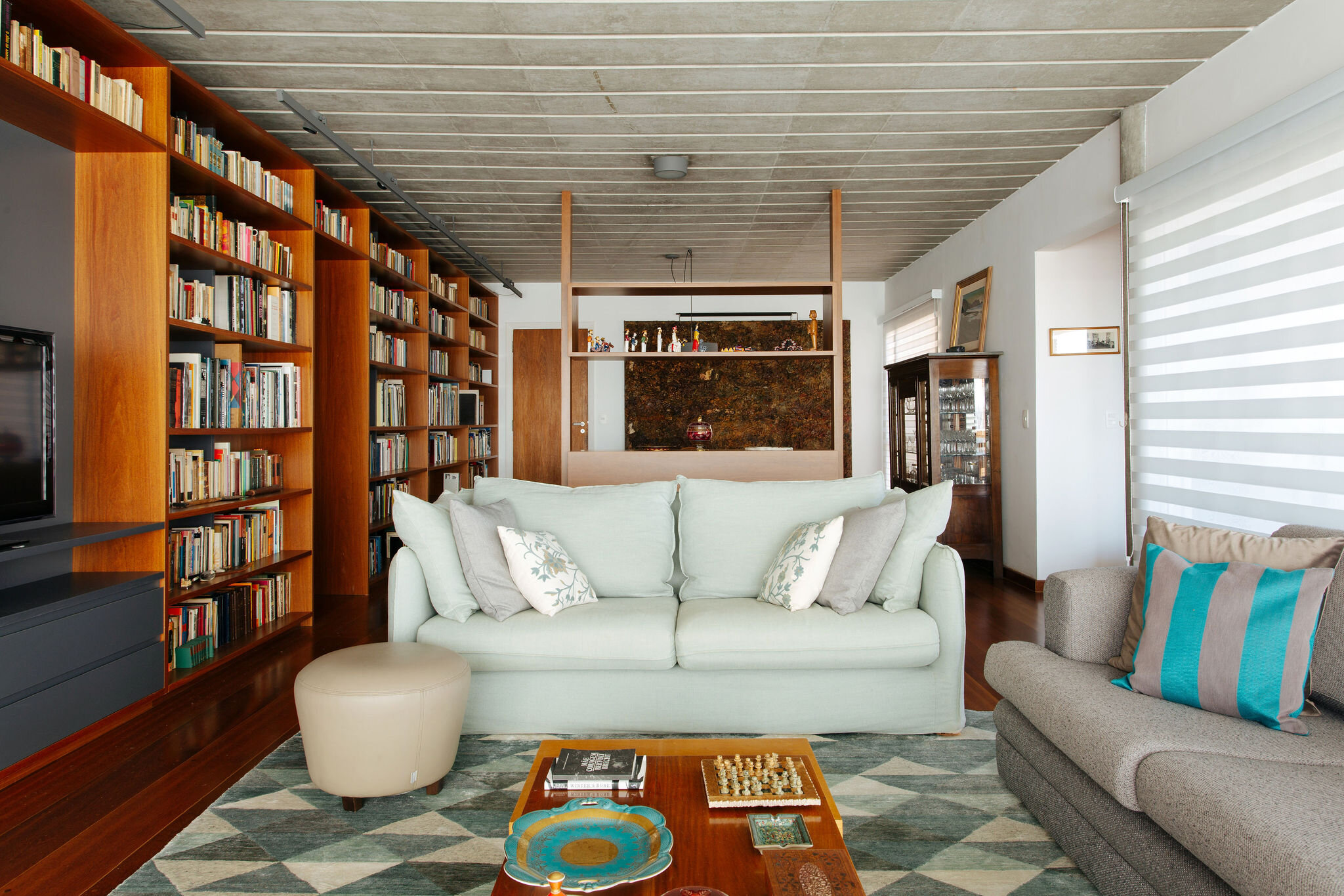 apartamento-reforma-sala-parede-livros-teto-concreto-aparente-sofa-branco.jpg