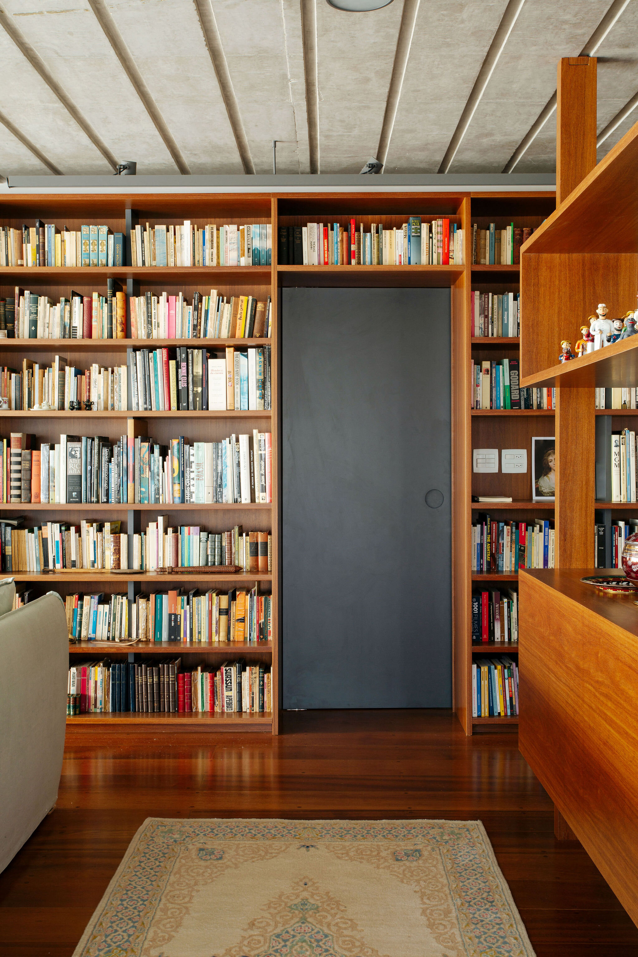 apartamento-reforma-sala-parede-livros-porta-formica-cinza.jpg