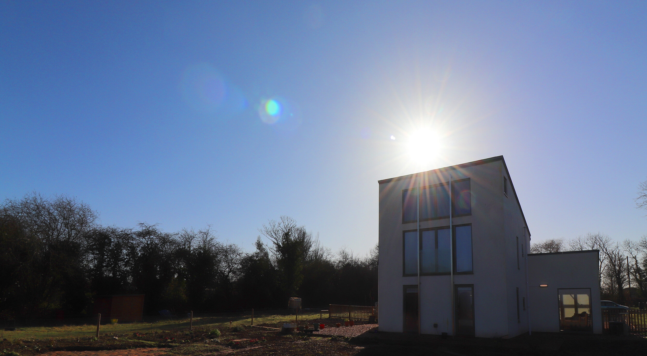 Sunset behind eco dwelling built with natural materials in suffolk 