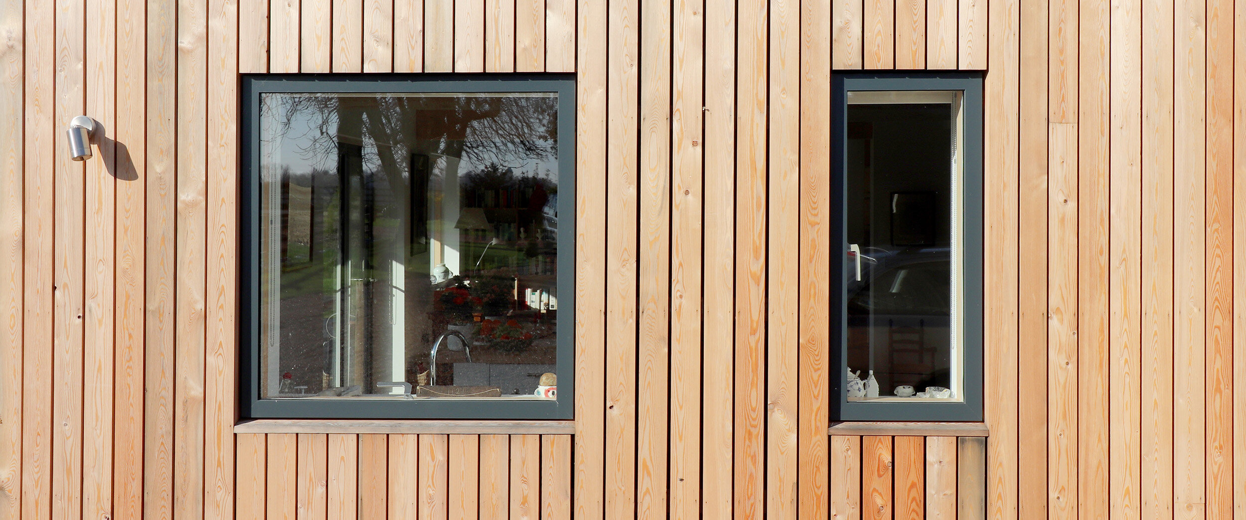 windows and doors designed to perfectly fit in with the spacing and rhythm of the vertical larch cladding