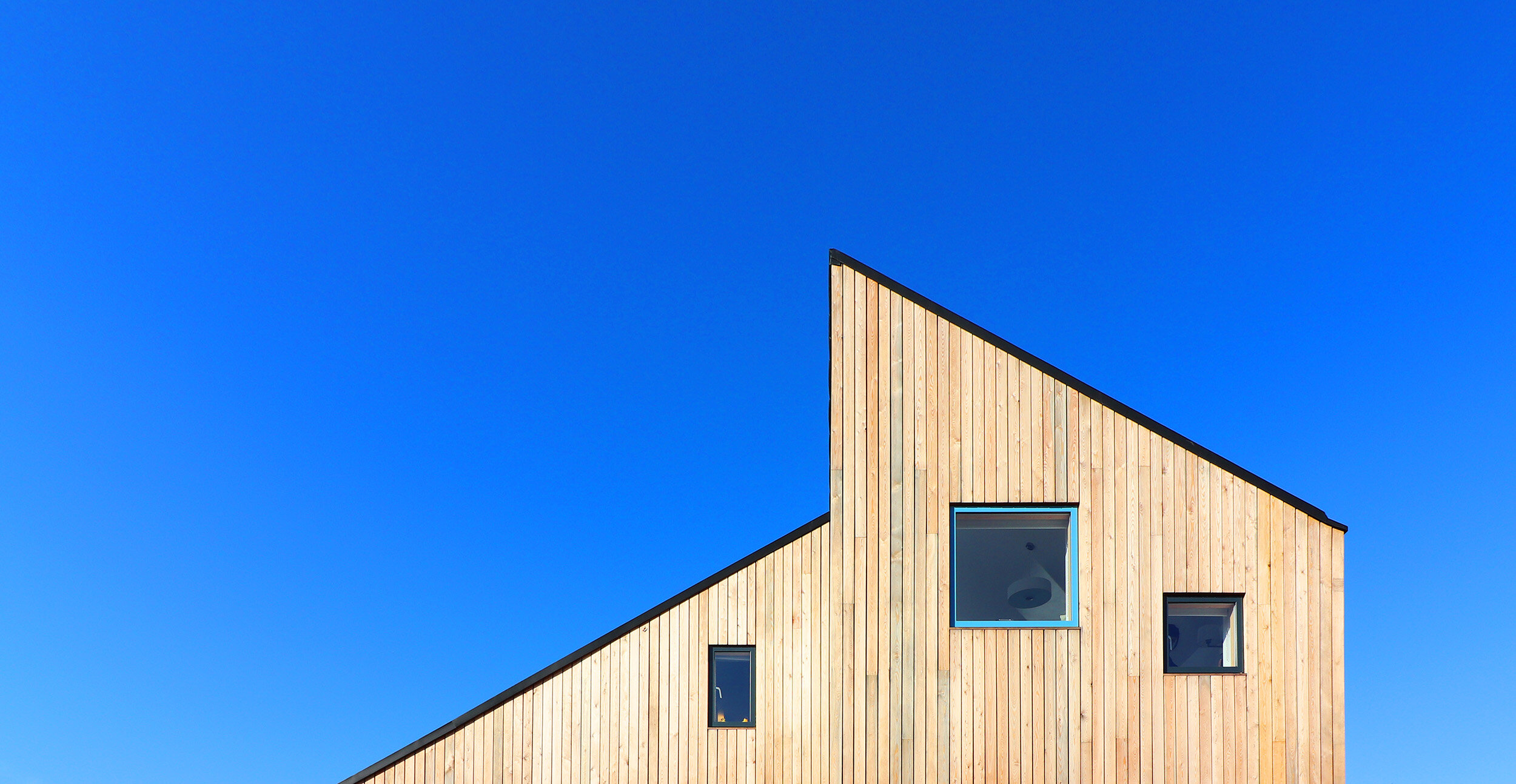 blue framed window mirrors the stunning sky in this larch clad eco dwelling in suffolk