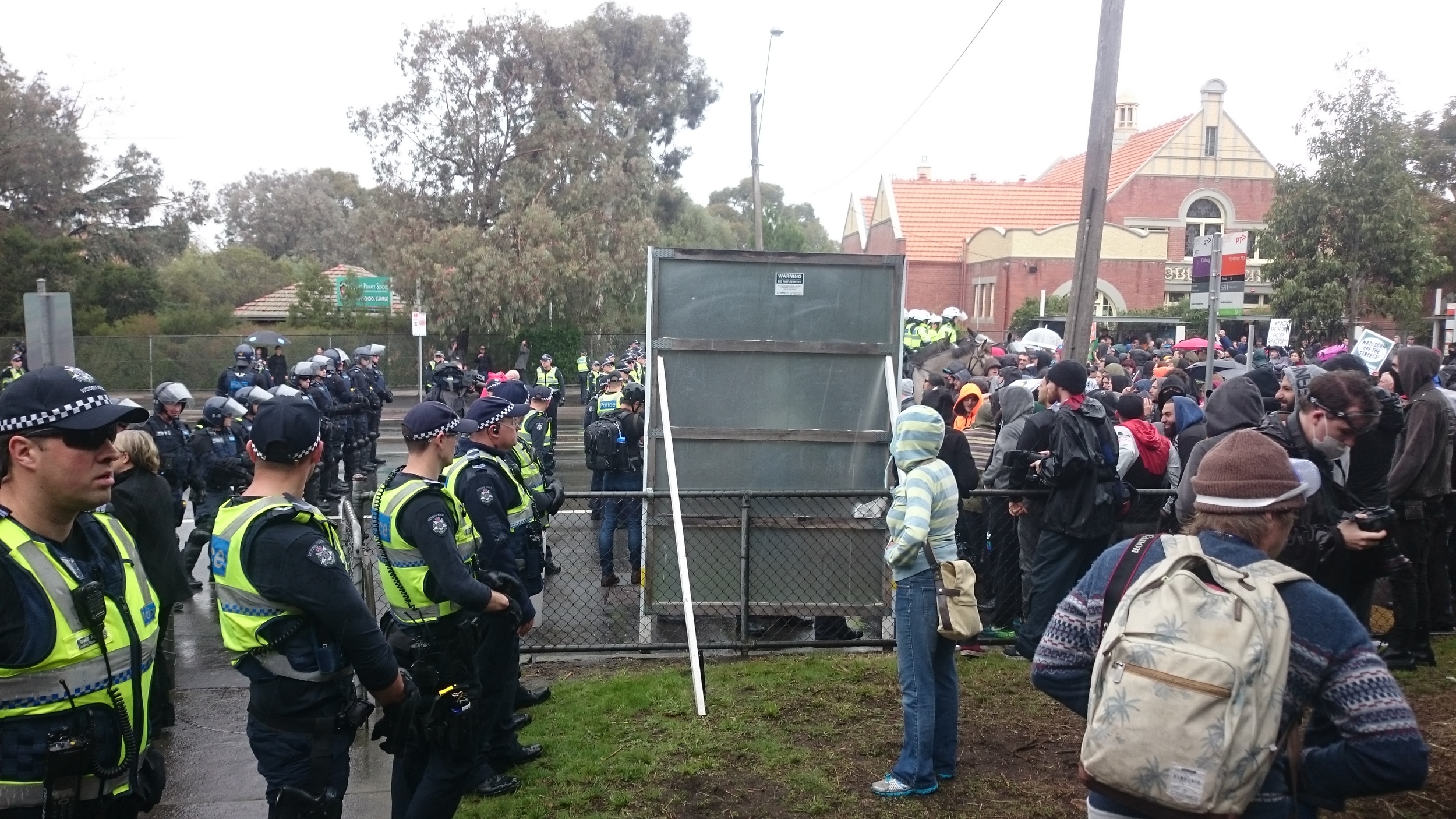 A line of police keeping the left-wing protesters away from the "Patriots".