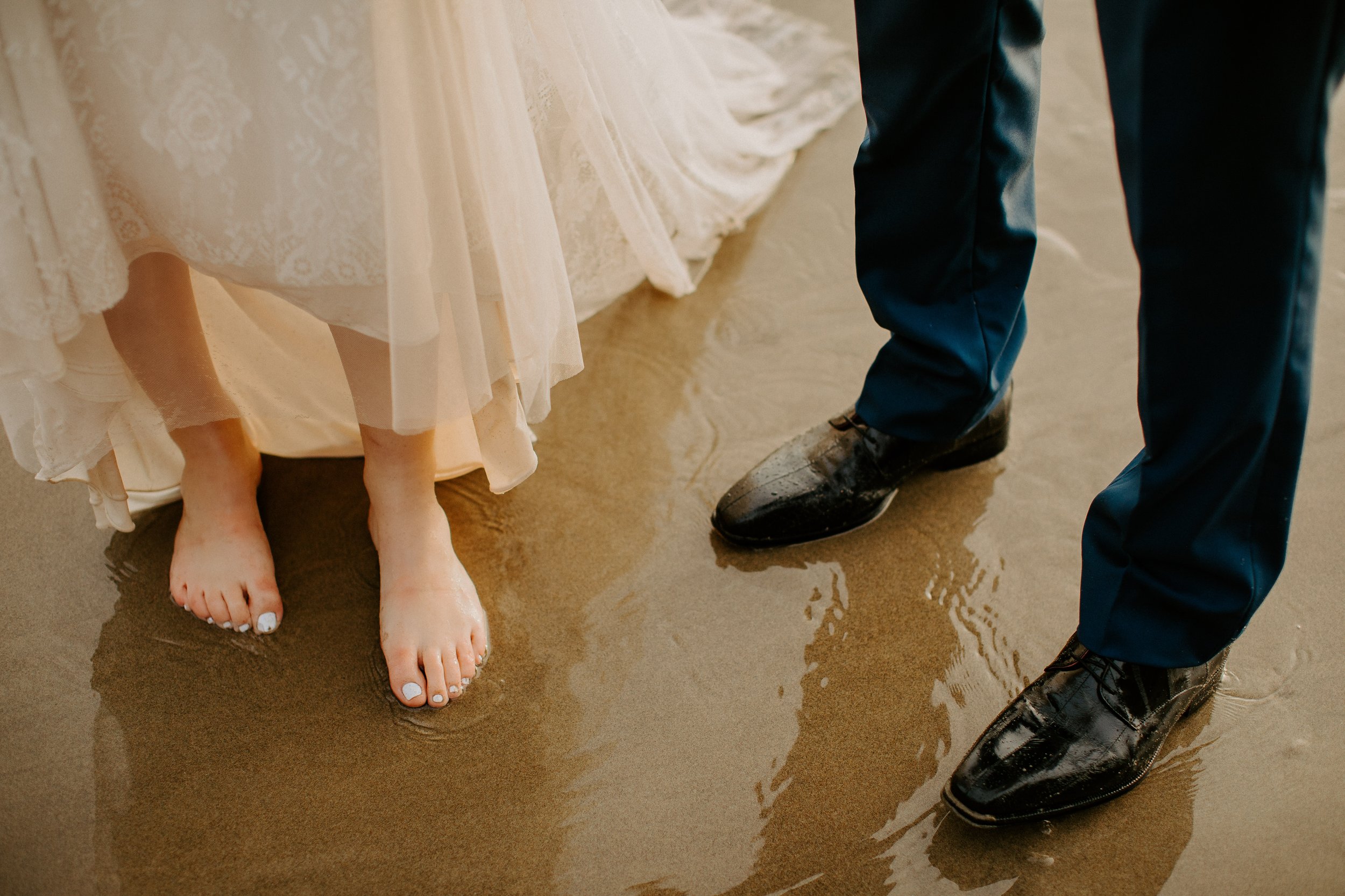 Bride and groom toes in the sand at Hug Point
