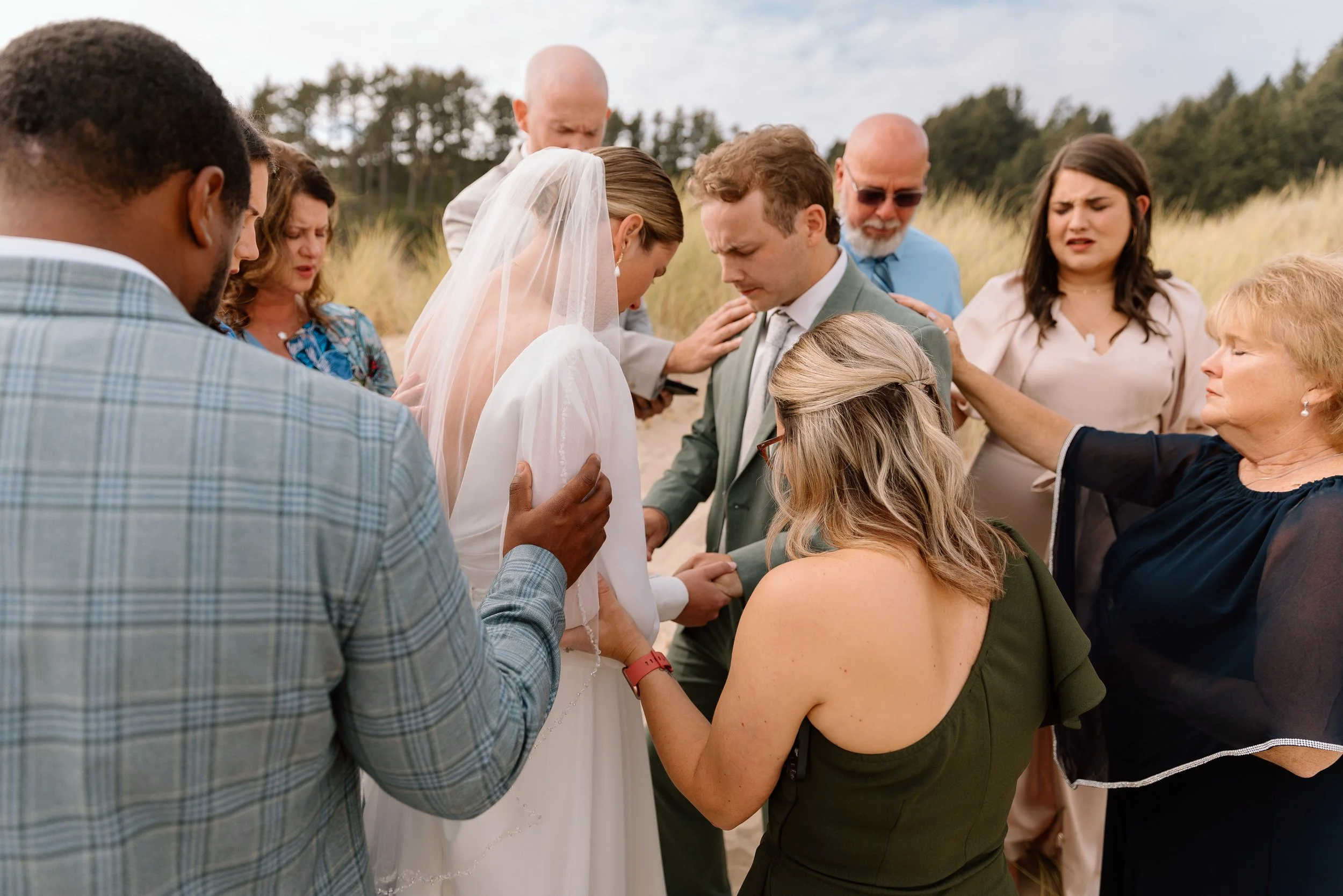 Family gathering around to pray for a couple at chapman beach oregon