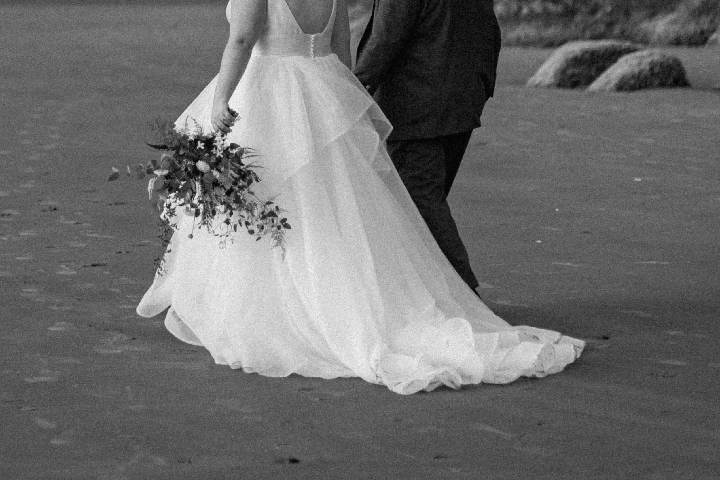 Bride and groom walking along the Oregon coast