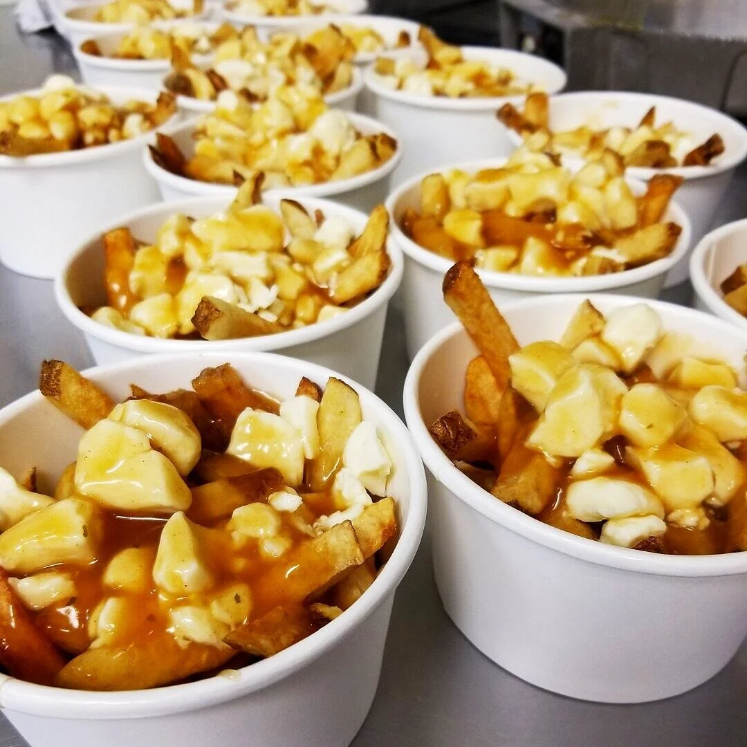 Cup of poutine with fries, cheese curds and gravy.