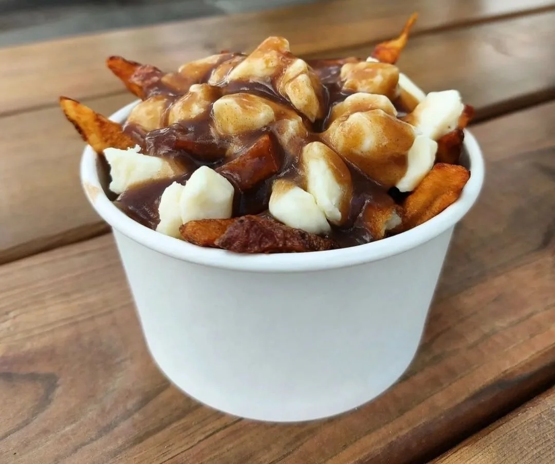 Cup of poutine with french fries, cheese curds, and brown gravy
