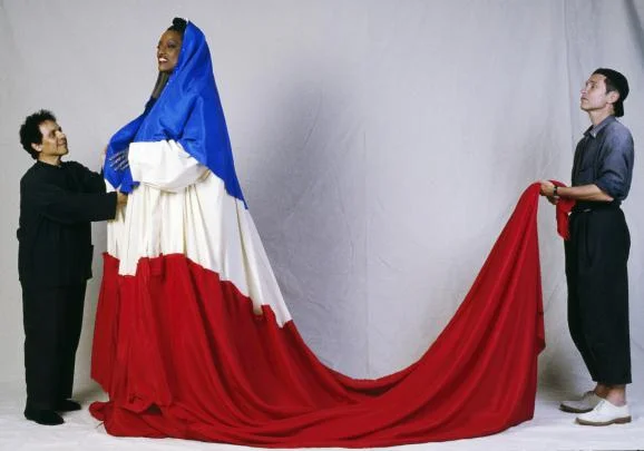 Le couturier Azzedine Alaïa, avec la cantatrice Jessye Norman et le chorégraphe Jean-Paul Goude, avant la cérémonie du 200e anniversaire de la révolution française. (PIERRE PERRIN / SYGMA / GETTY IMAGES)