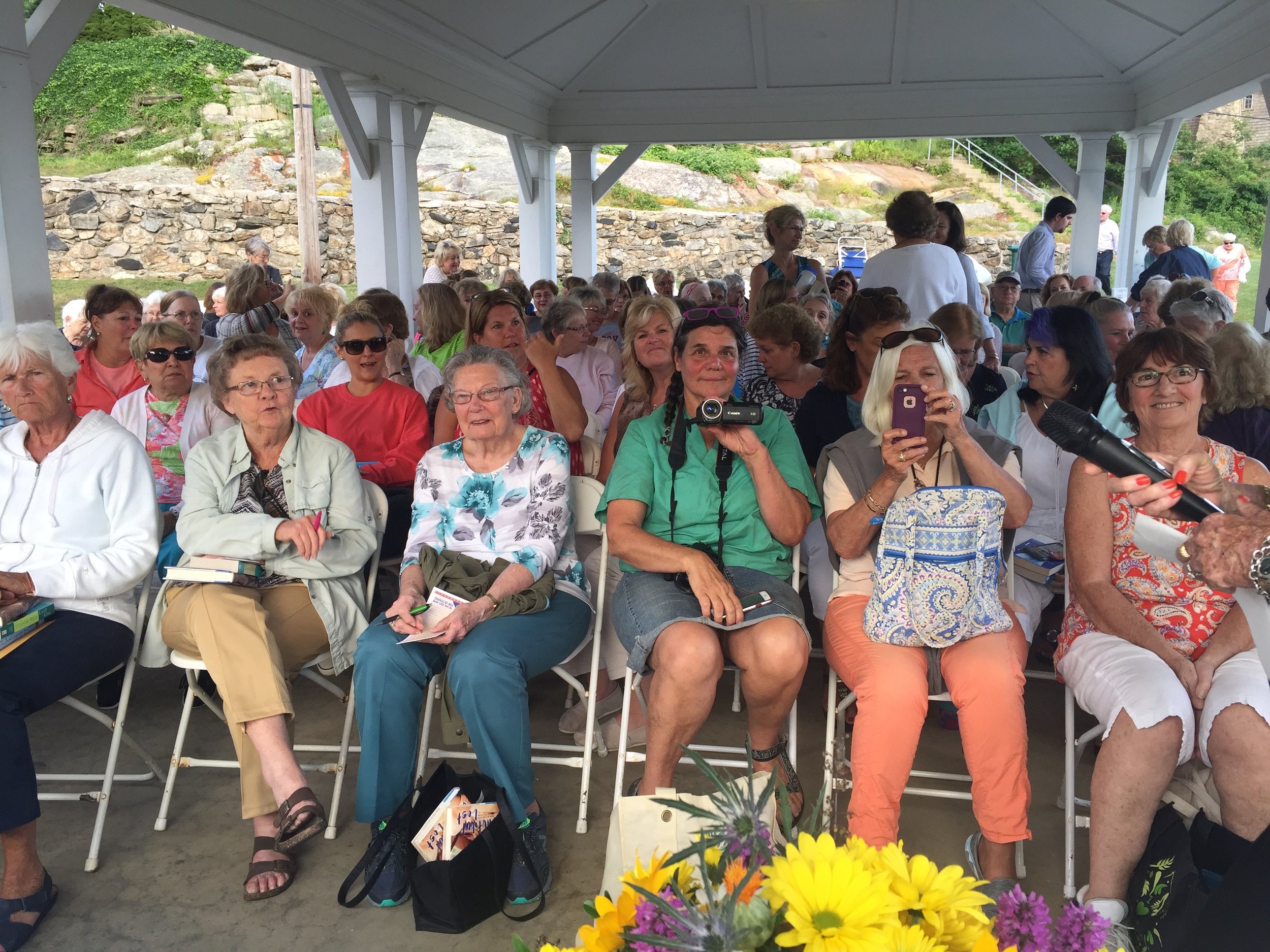 The pavilion was full, with extra chairs curving out to the basketball court and stone wall. 