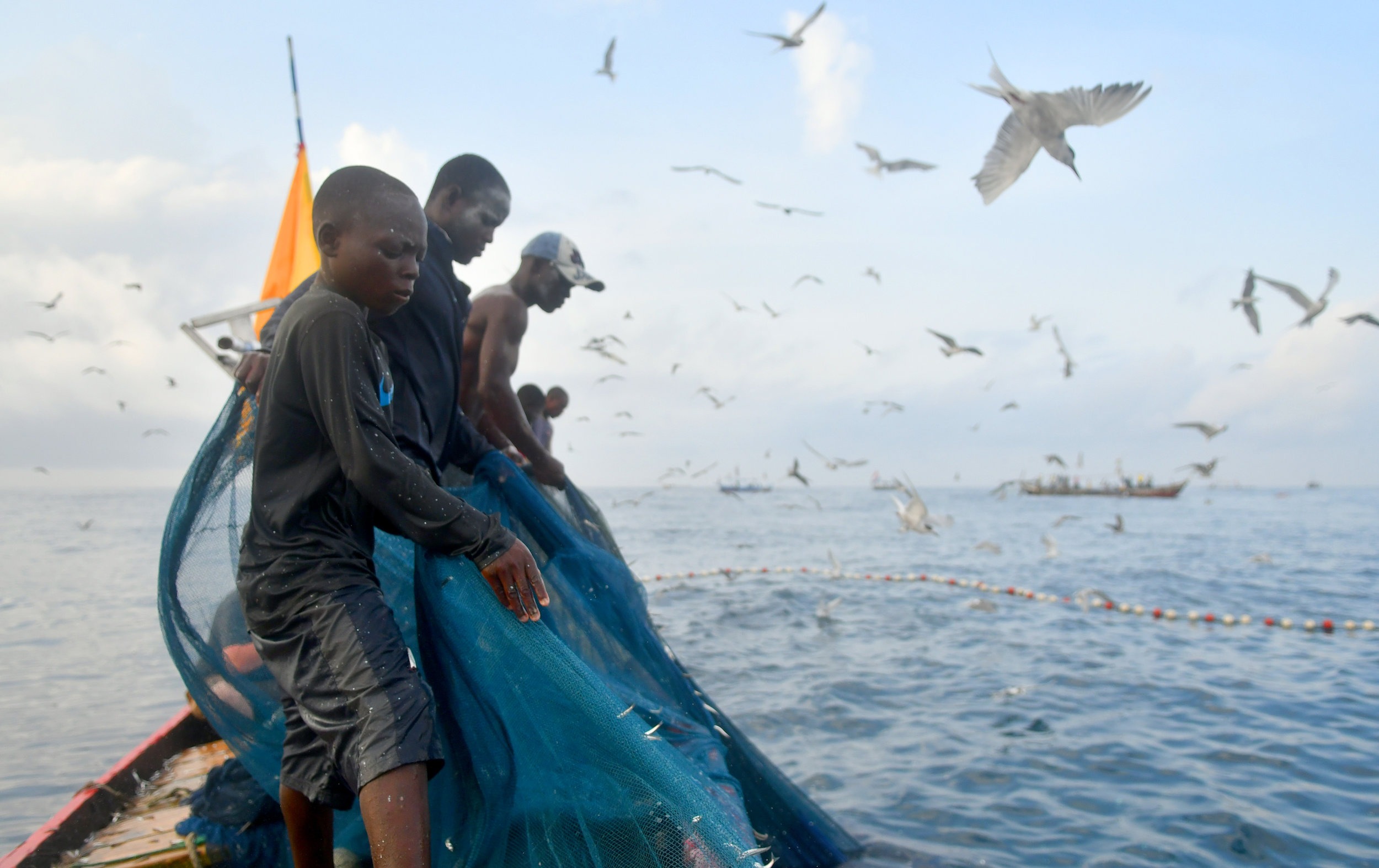  Everyone works hard to pull in a net off the coast of Ghana on Tuesday, March 30, 2017. Even the youngest crew member, Bernard Mate Batu, 9, pulls alongside his elders. He and the other men on the boat all start young when they learn how to fish, mo