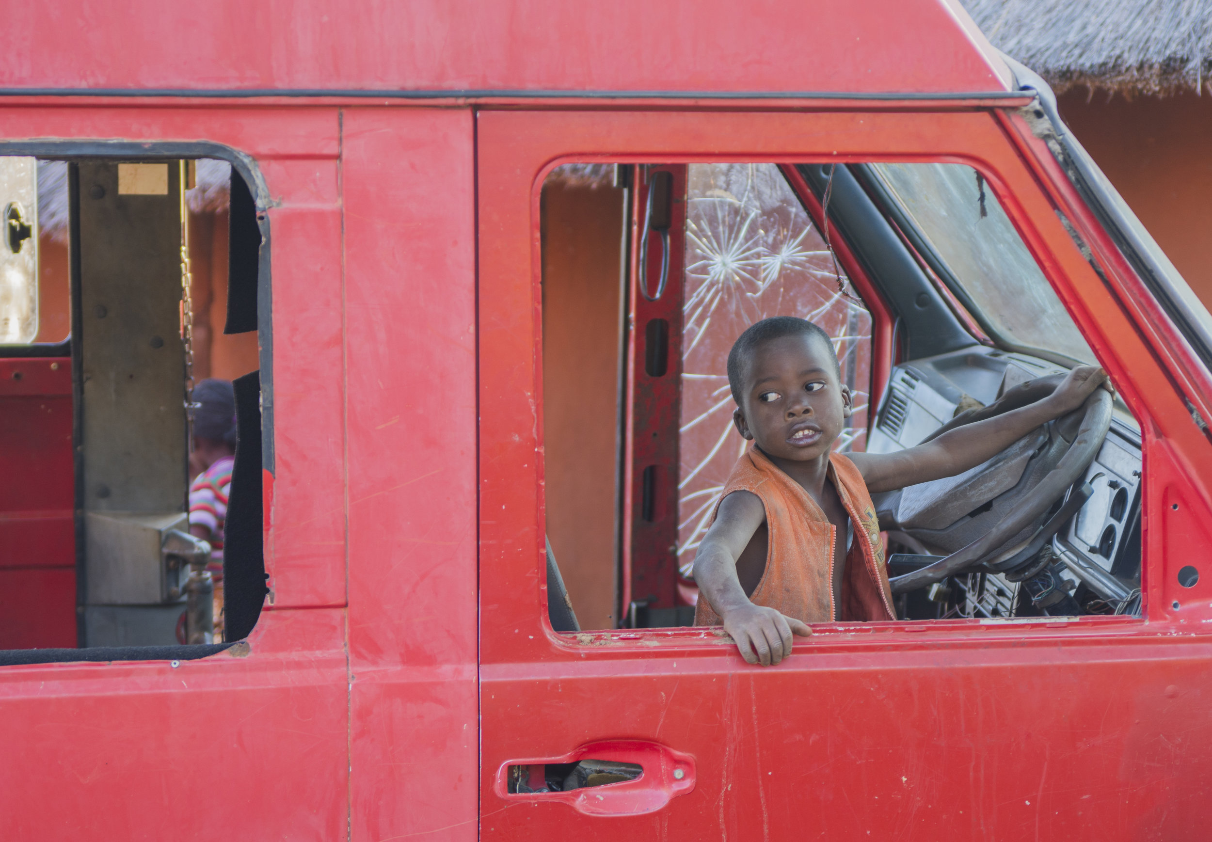  A young boy plays in the shell of a van in northern Zimbabwe. African Impact and ALERT partner with this village as an educational tool to teach volunteers about Zimbabwe culture and to help the village craftsman sell their wares. 