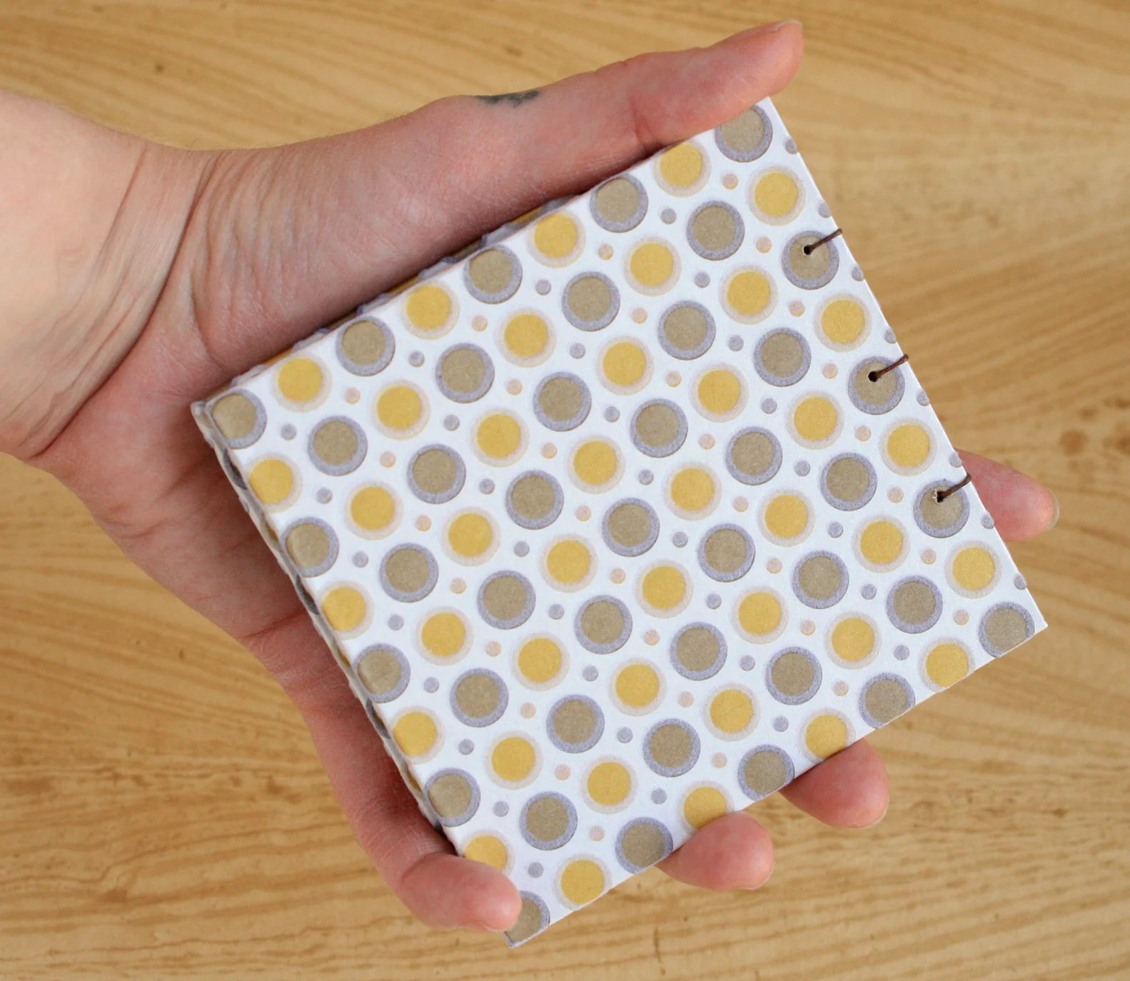 small-coptic-100-pg-with-flocked-dots-in-hand.jpg