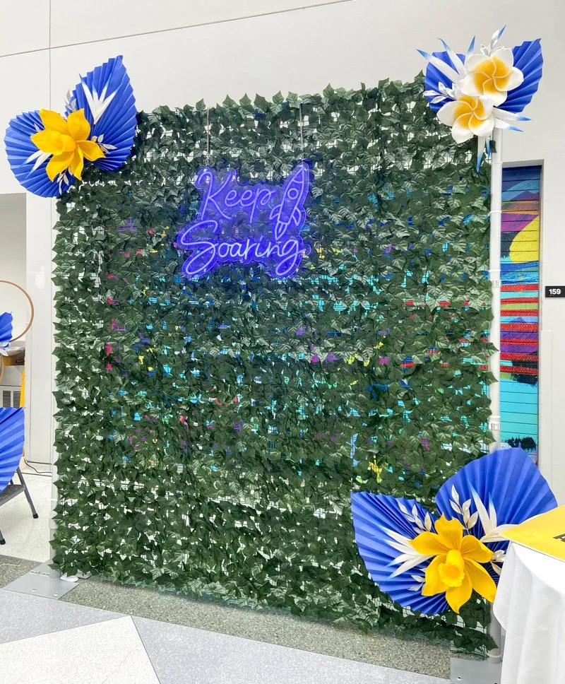 Ivy wall photo backdrop with neon sign and paper flowers