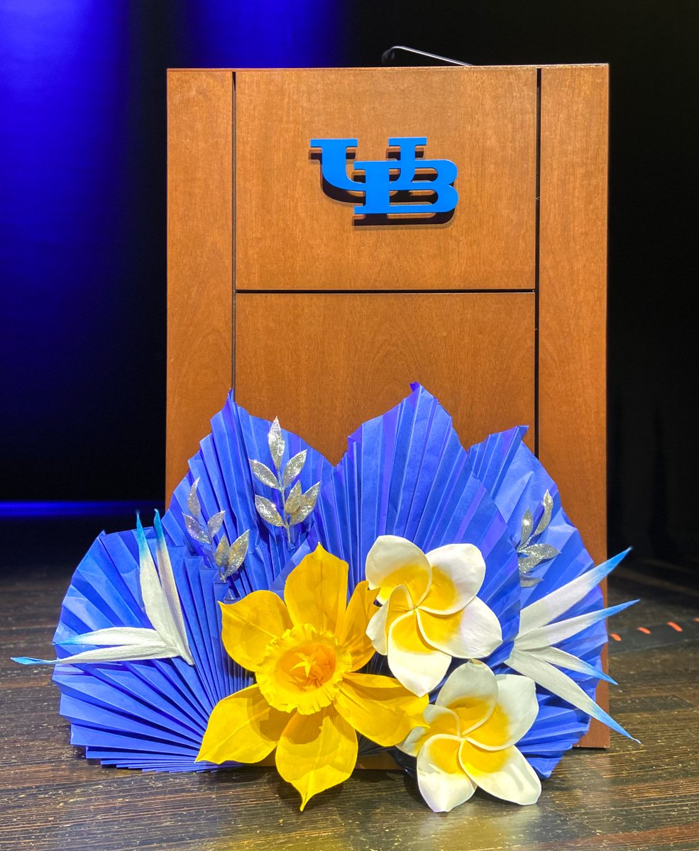 Yellow and blue paper flower decor on a podium