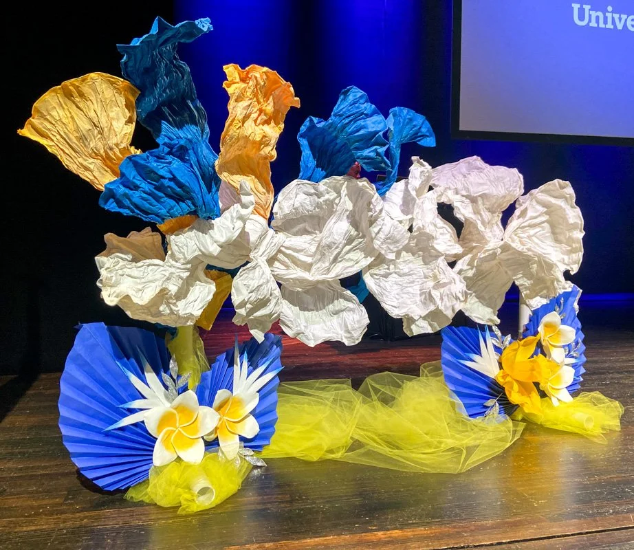Abstract paper installation on a stage with yellow, blue and white paper flowers