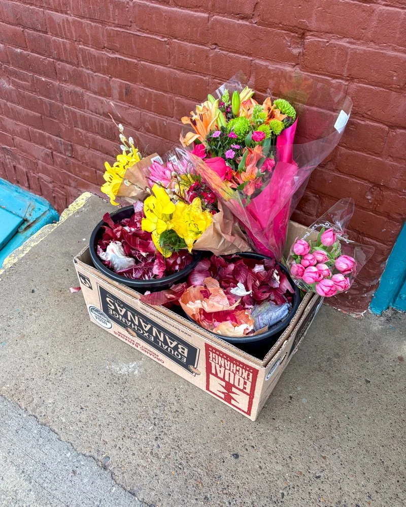 Cardboard box with flower bouquets and food scraps