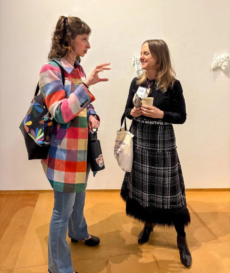 White women talking in an art gallery