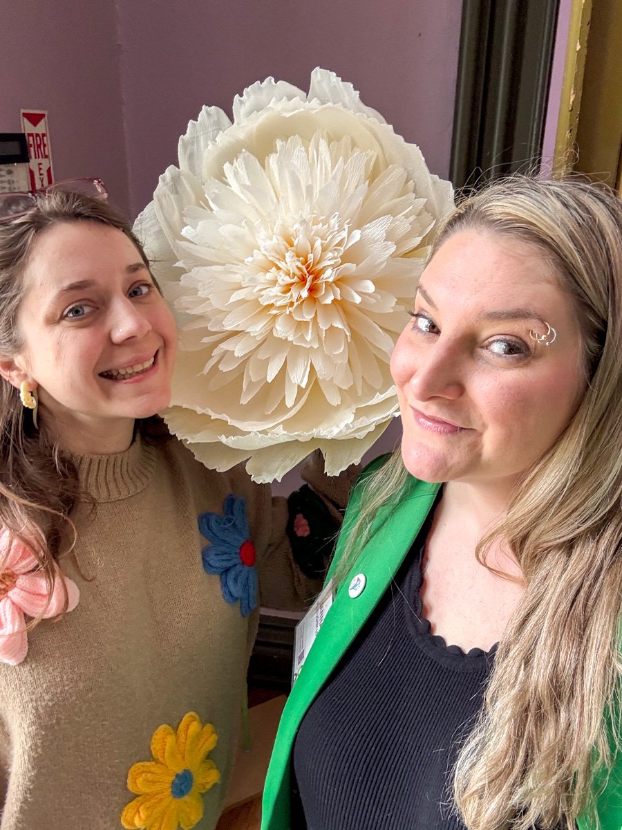 Two White women and a giant paper flower