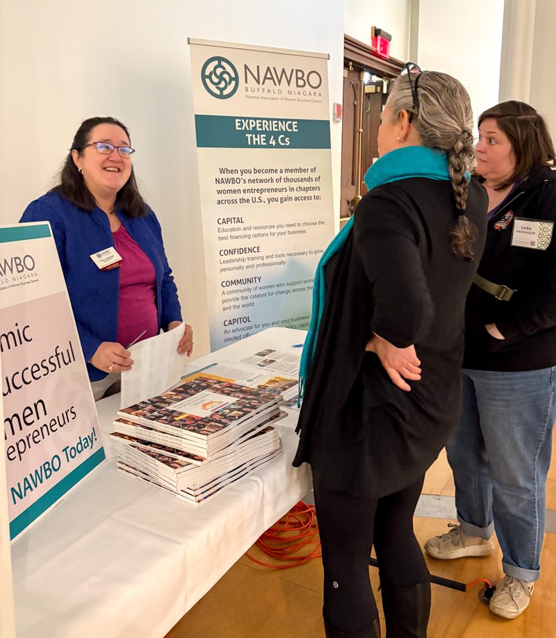 White women talking at an informational table for NAWBO