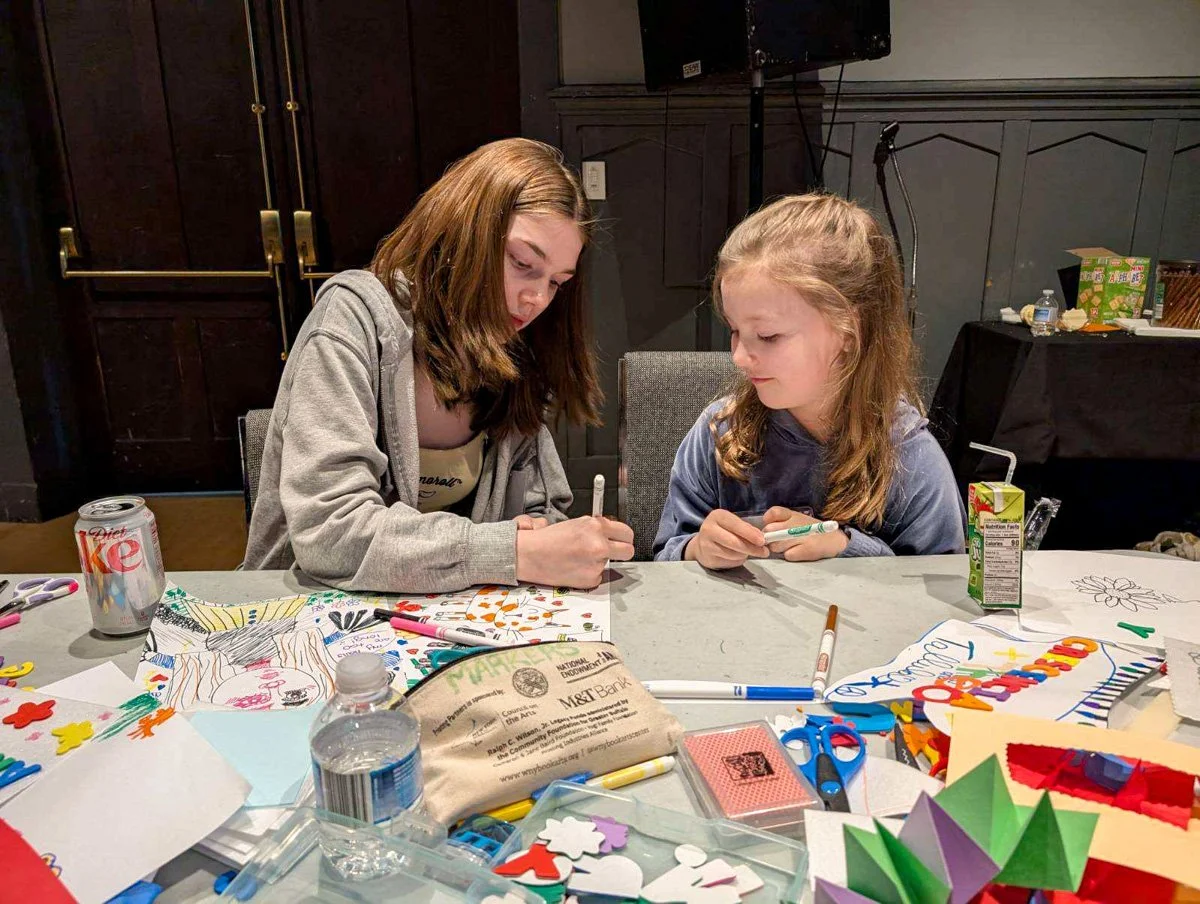 Childcare provider and child making art at an art event