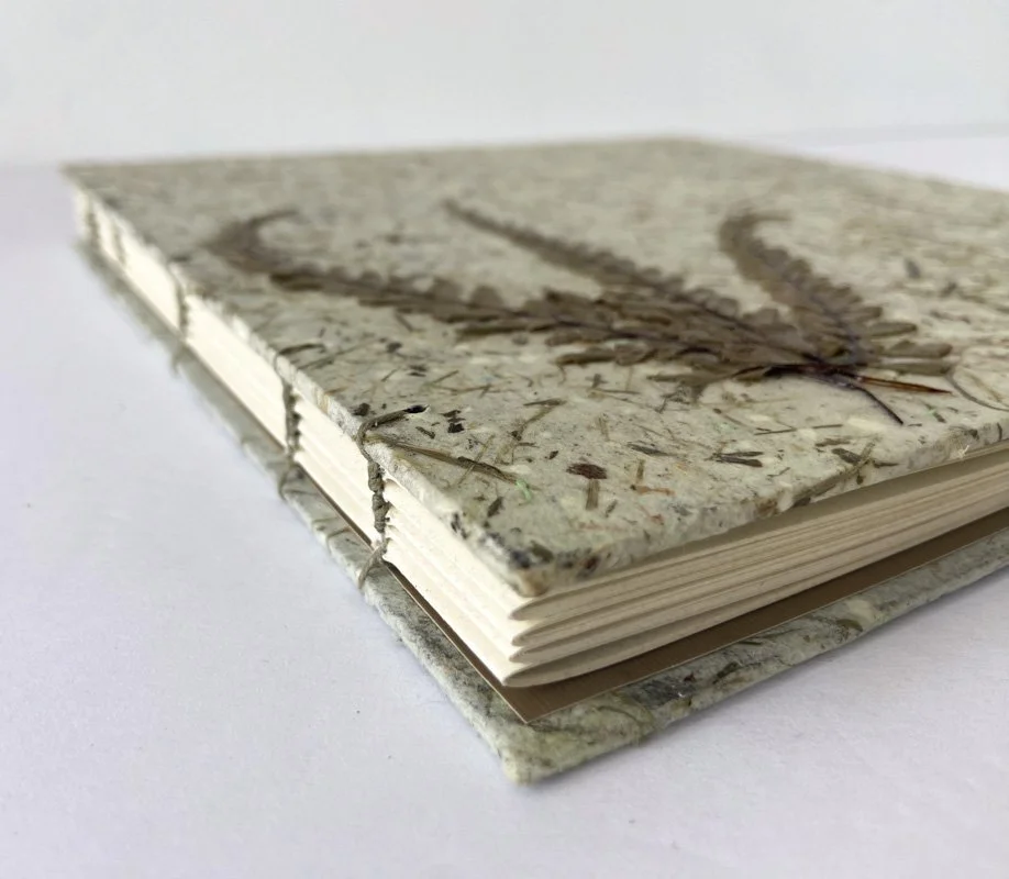 Handmade journal with a textured natural fiber paper cover and exposed binding