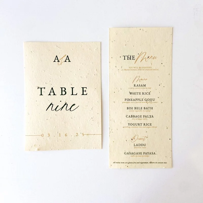 Handmade paper wedding table number and menu cards with elegant black and gold typography