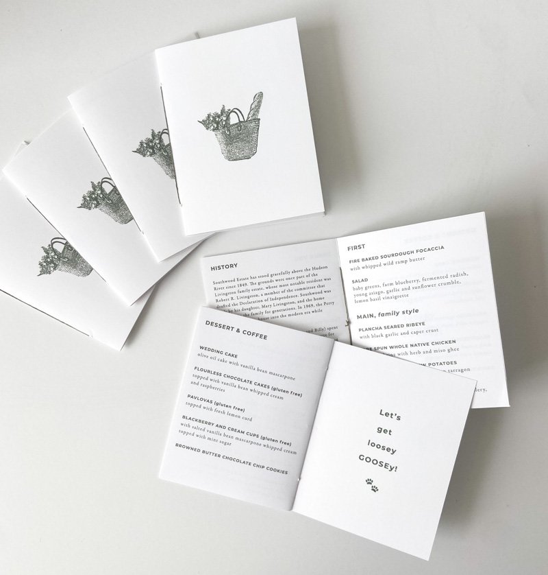 Custom wedding menu booklets featuring a simple botanical illustration and printed dinner details