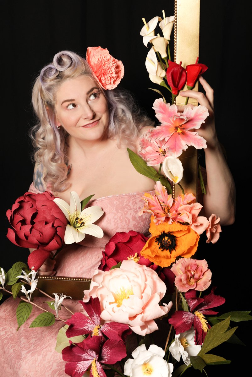 Janna Willoughby-Lohr surrounded by colorful handmade paper flowers