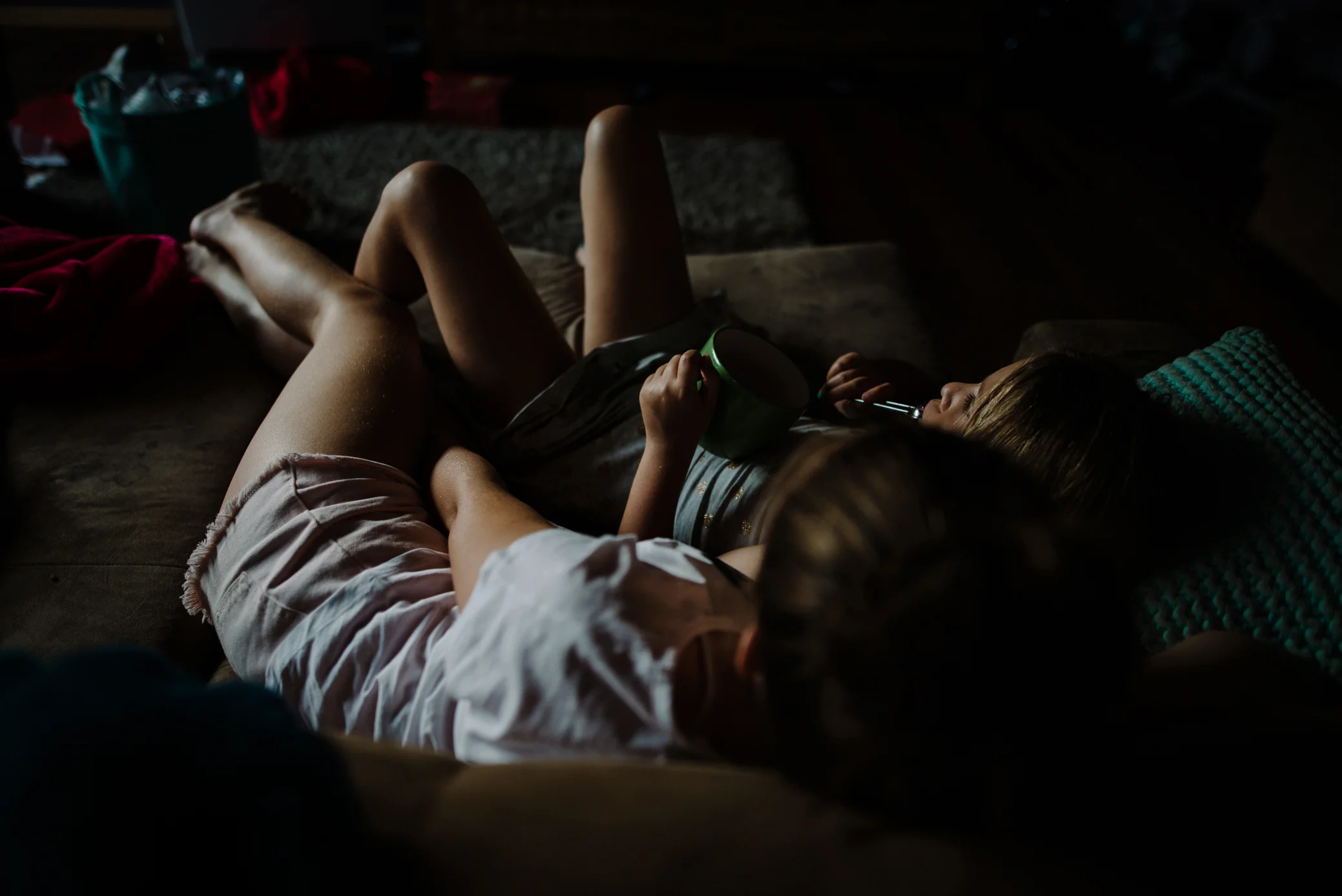 Sisters hugging on the lounge by Cindy Cavanagh