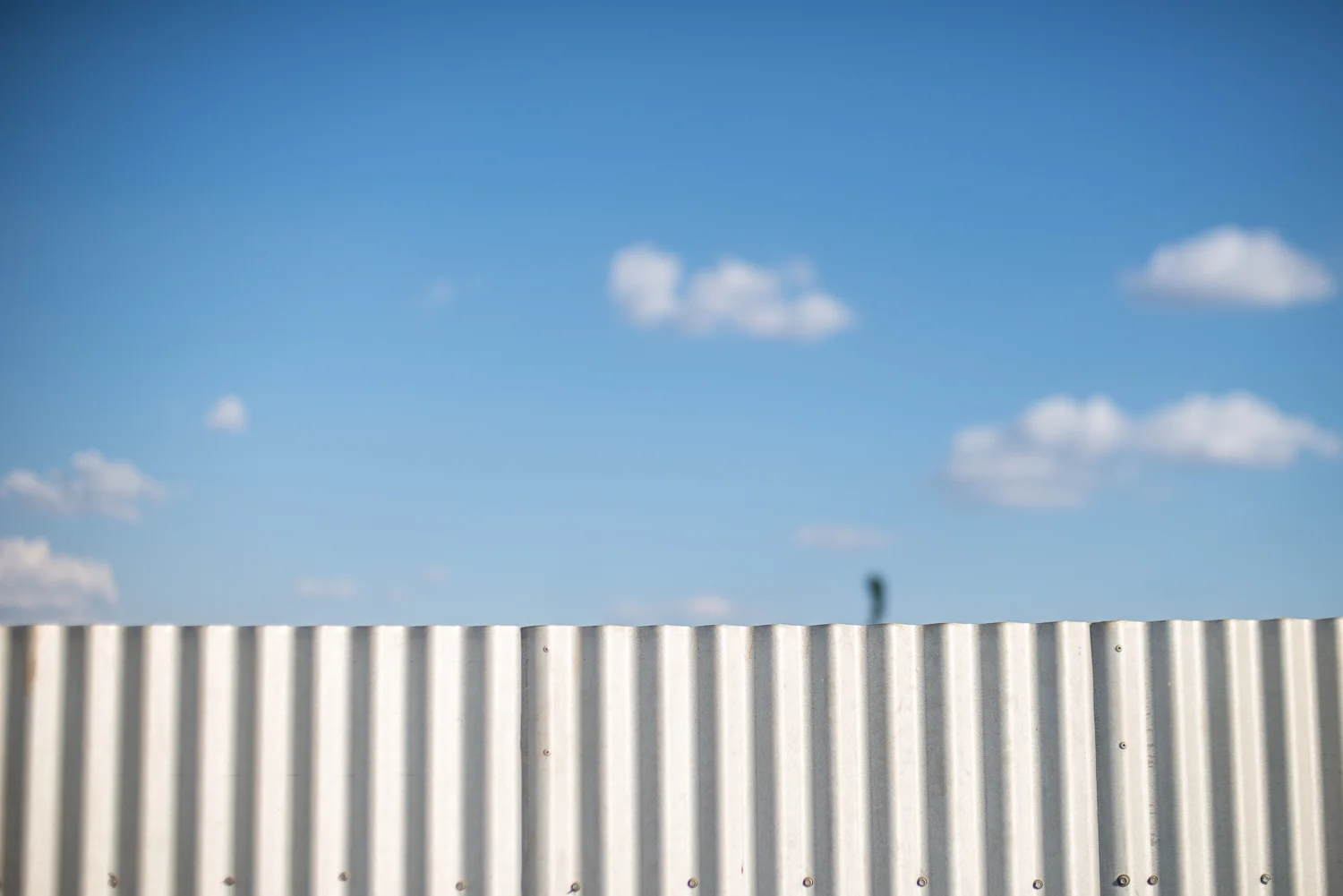 A blue sky over a fence