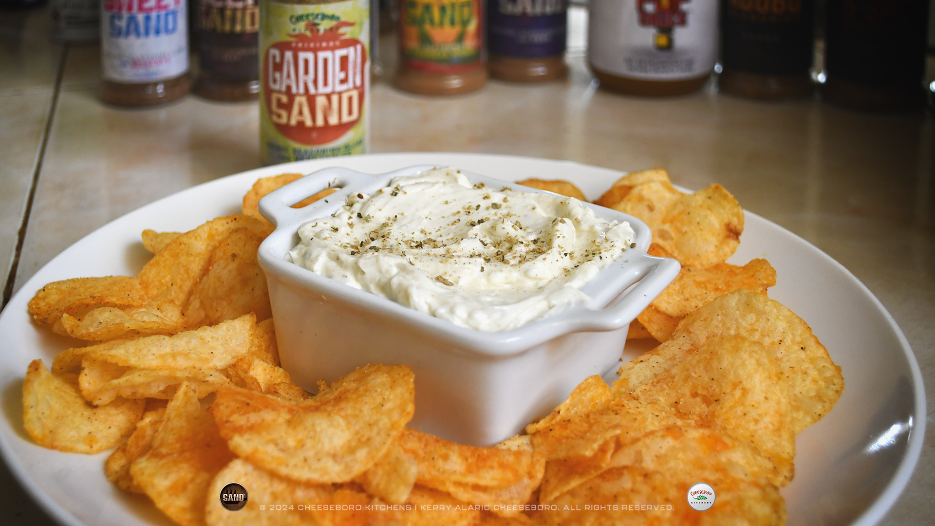 cheeskitch-240212-sand-garden-party-dip-on-plate-with-potato-chips-with-jar-1-1920-hor.png