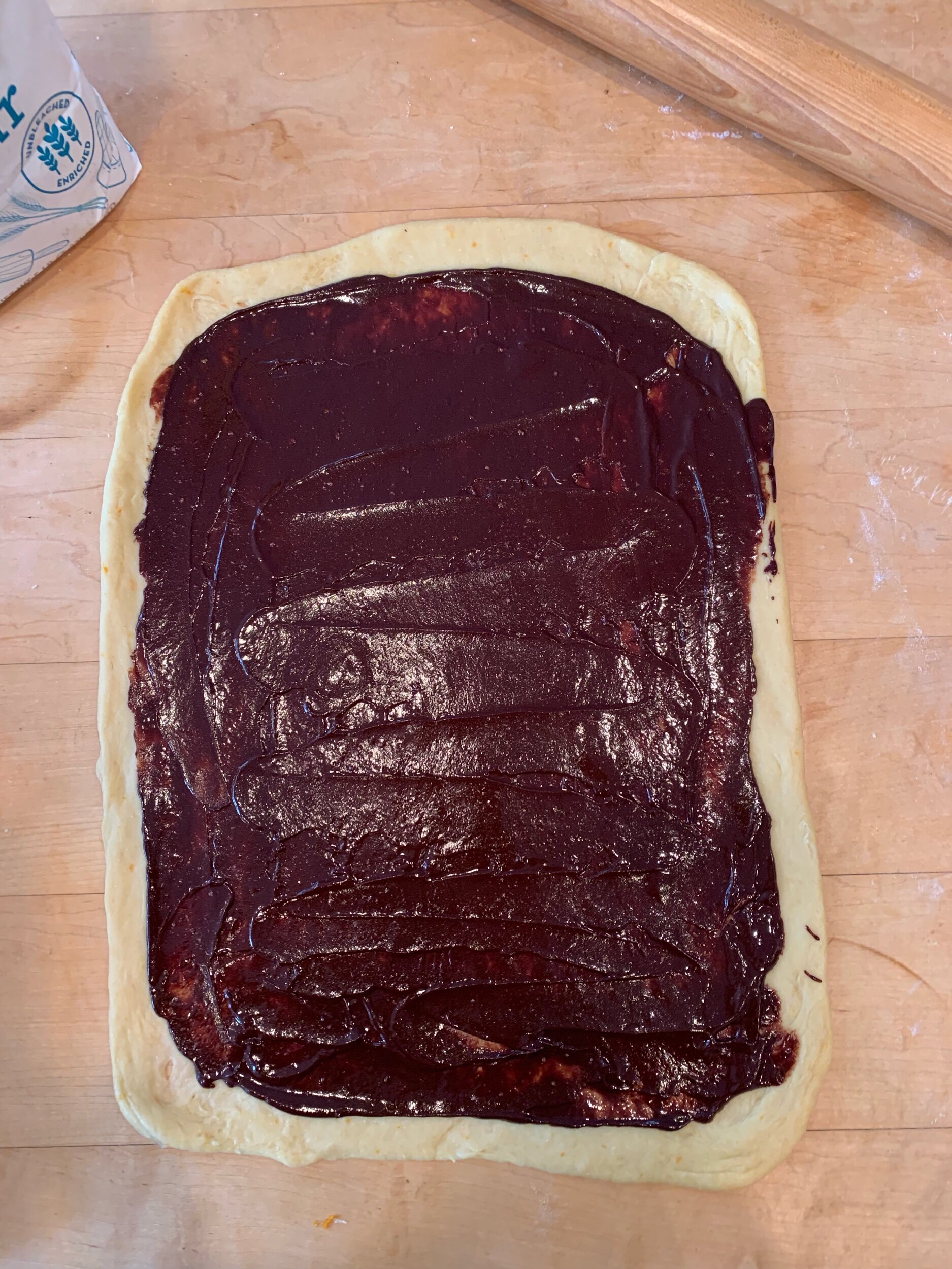 Roll the dough and then spread with the chocolate filling.