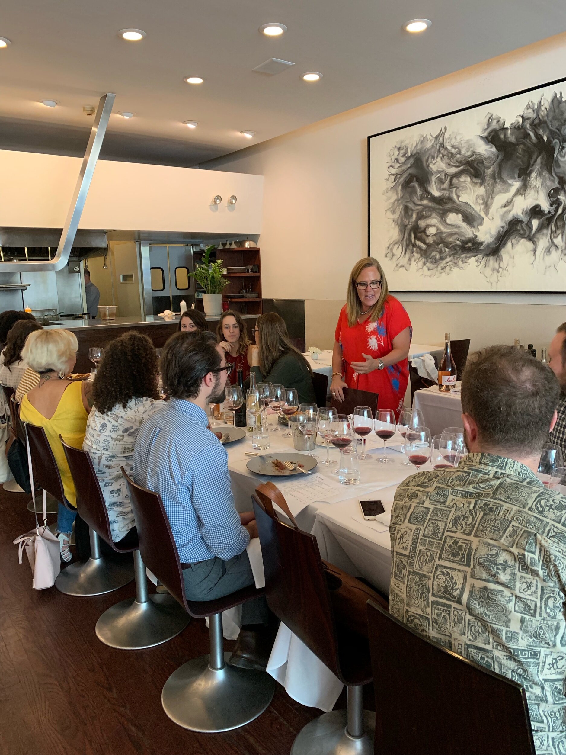 Sara holding court sharing and her wine for the people philosophy
