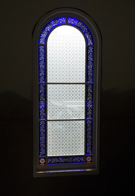 Victorian Arched window with continuous pattern ans blue glass
