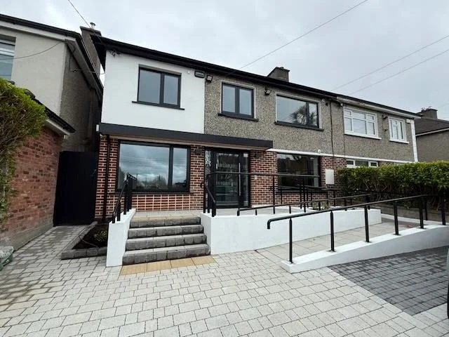 Front view of a two-story residential building with a wheelchair accessible ramp and steps.